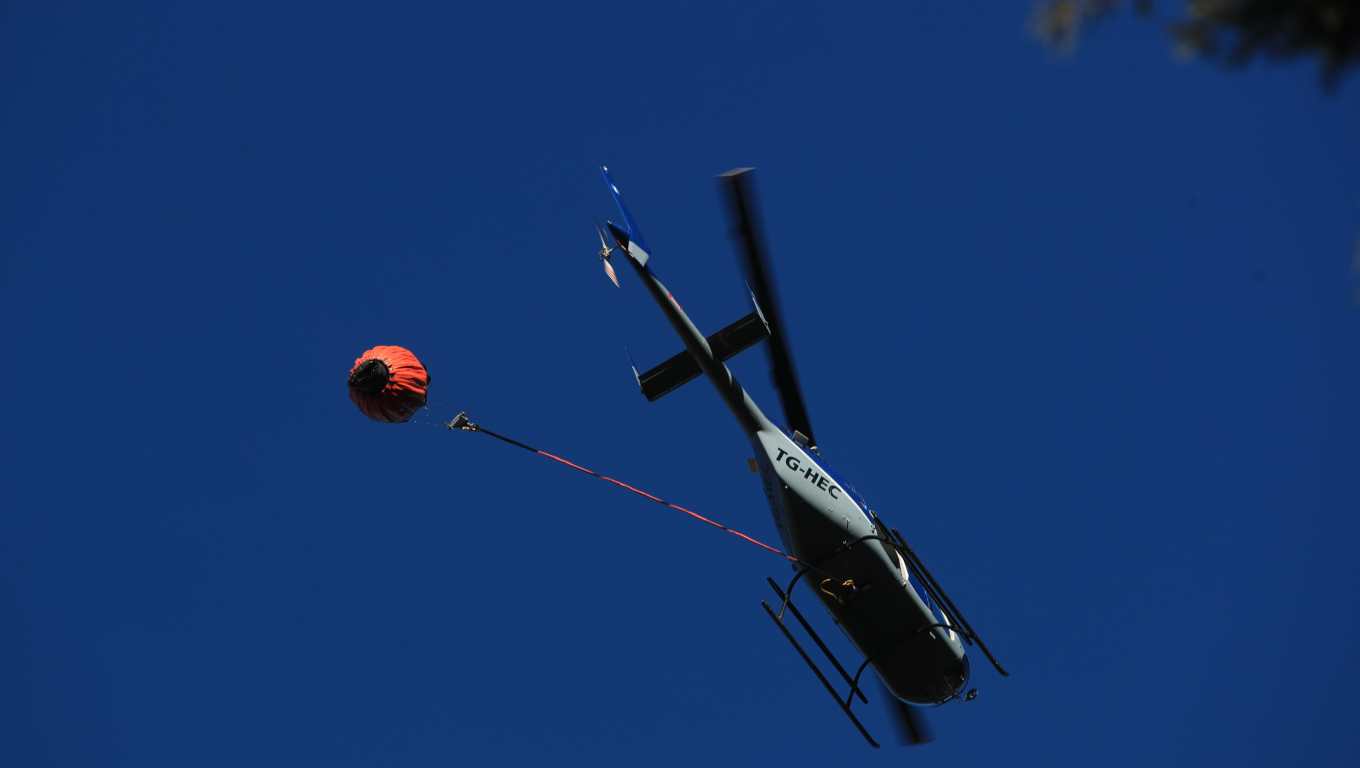 Helicóptero privado que apoya en las tareas de apagar el fuego en el Volcán de Agua. (Foto Prensa Libre: Carlos Hernández)