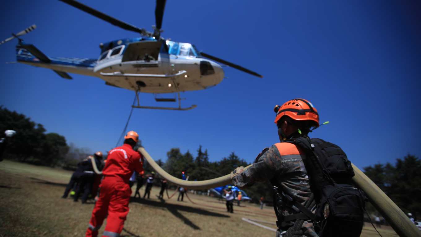 Helicópteros, aviones, fumigadores y cuerpos de socorro trabajan para apagar el incendio en el Volcán de Agua. (Foto Prensa Libre: Carlos Hernández Ovalle)  