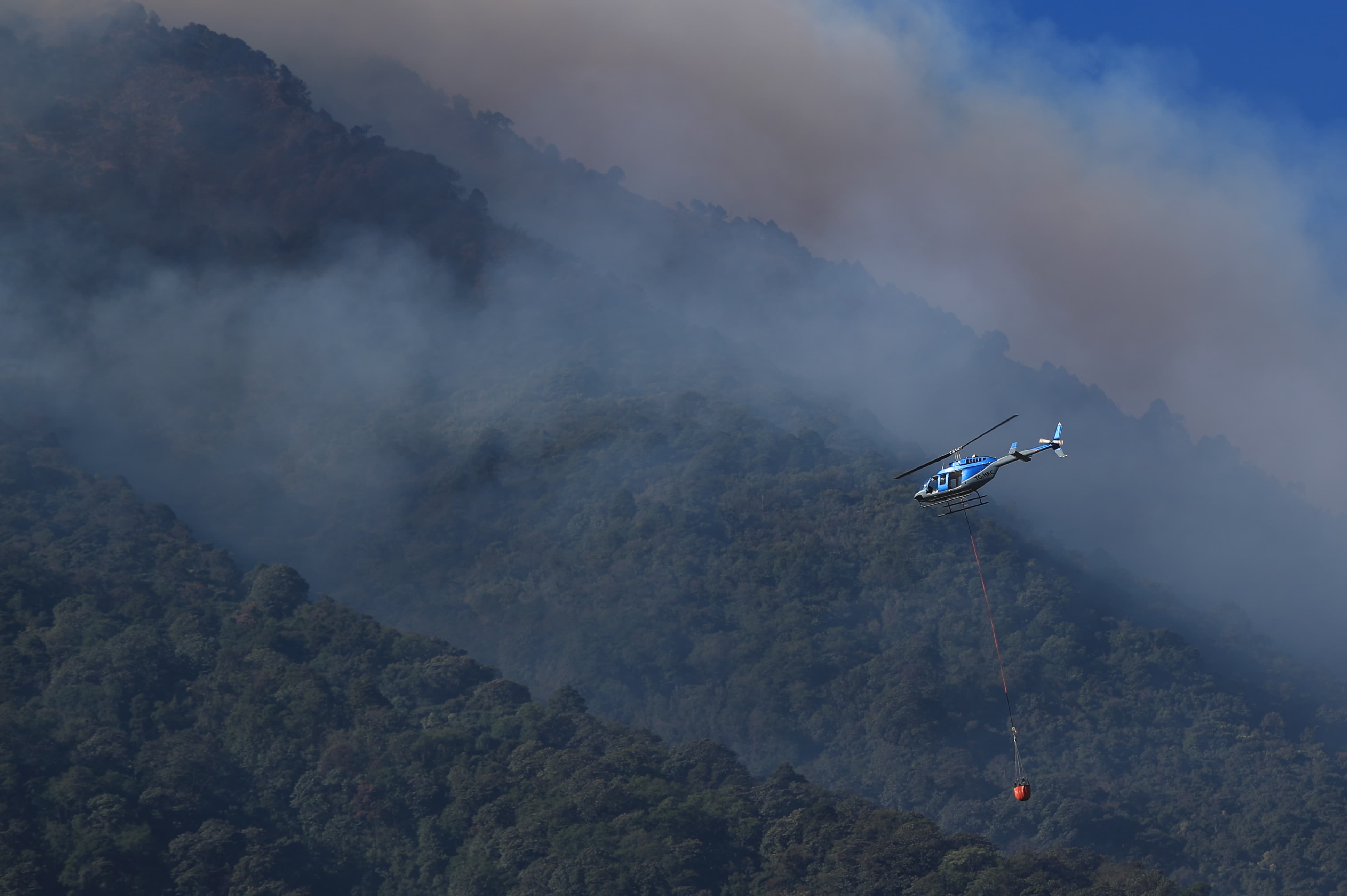Diversas instituciones hacen labores de combate a un incendio forestal en el volcán de Fuego. Usan helicópteros para lanzar agua hacia el fuego. (Foto Prensa Libre: Carlos Hernández Ovalle).