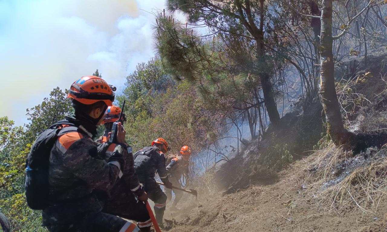Bomberos forestales trabajan en la zona donde ocurren los incendios en el Volcán de Agua. (Foto Prensa Libre: Ejército de Guatemala)