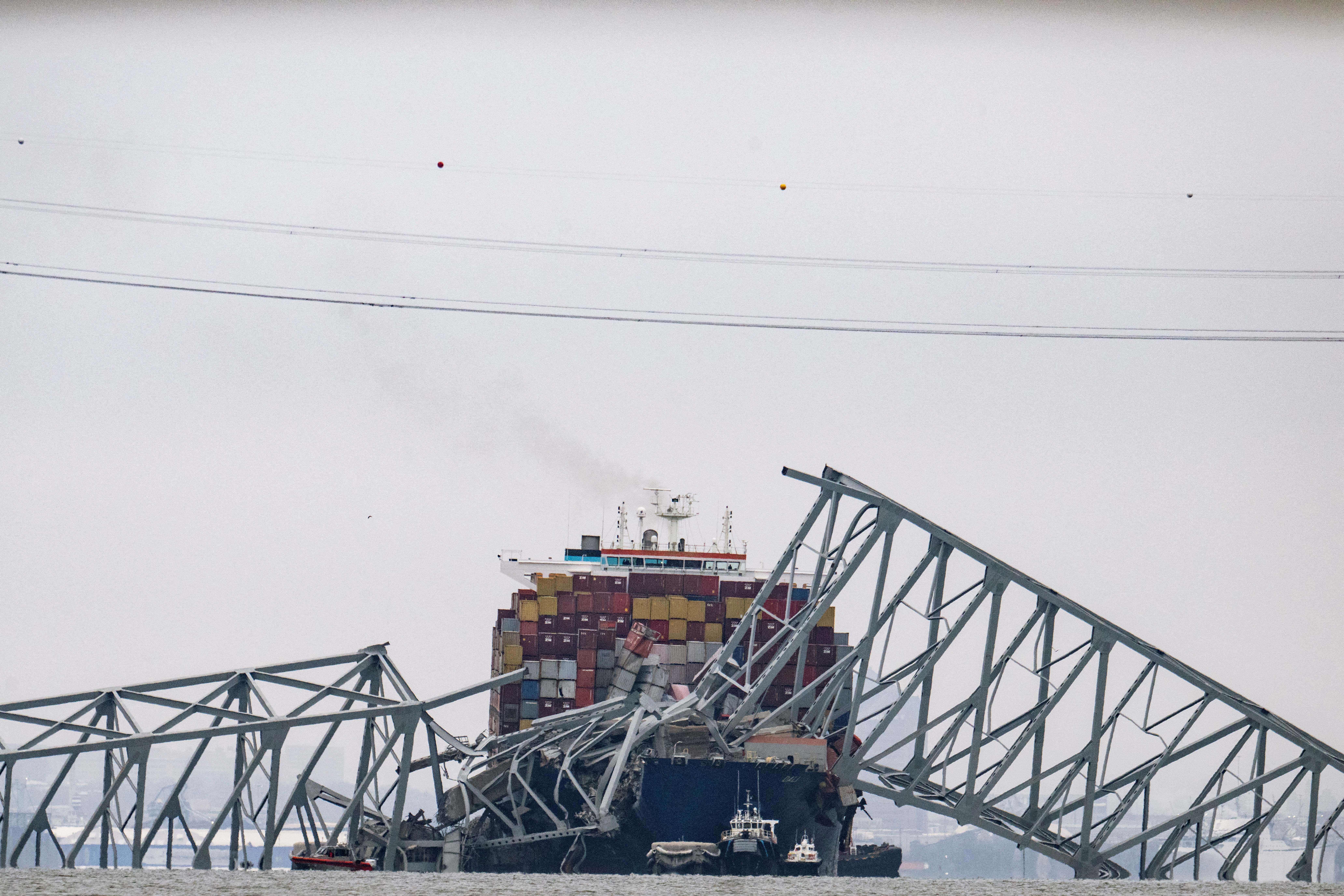 The collapsed Francis Scott Key Bridge lies on top of the container ship Dali in Baltimore, Maryland, on March 27, 2024. Authorities in Baltimore were set to focus on expanding recovery efforts on March 27 after the cargo ship slammed into the bridge, causing it to collapse and leaving six people presumed dead. All six were members of a construction crew repairing potholes on the bridge when the structure fell into the Patapsco River at around 1:30 am (0530 GMT) on March 26. (Photo by Jim WATSON / AFP)