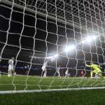 El guardameta de la Real Sociedad, Alex Remiro, intenta detener el remate del delantero del PSG, Kylian Mbappé.