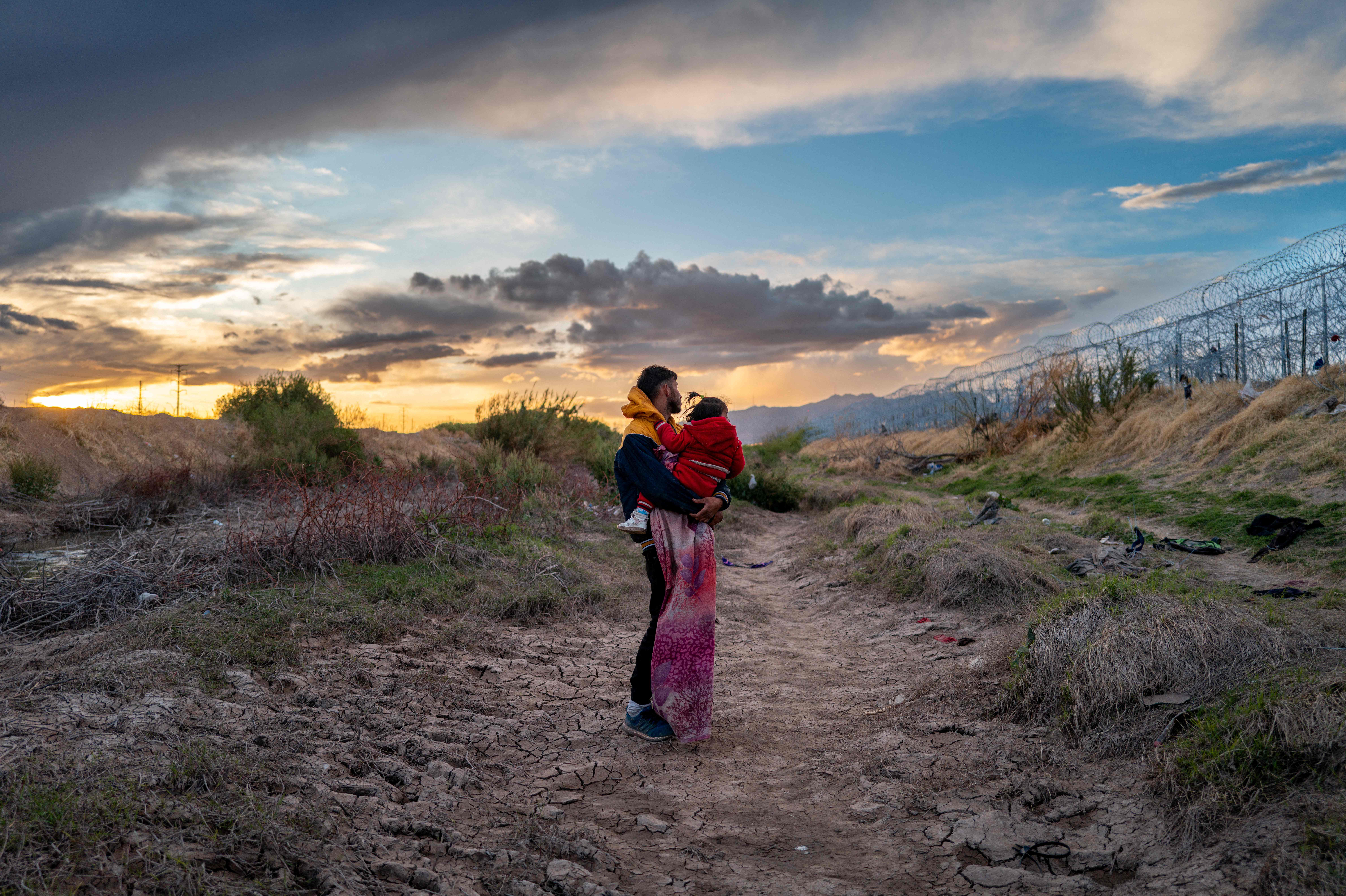 El migrante peruano Jordan y su hija Briana, de 1 año, esperan a que su grupo de migrantes se prepare para cruzar a los Estados Unidos (Foto Prensa Libre: AFP) 