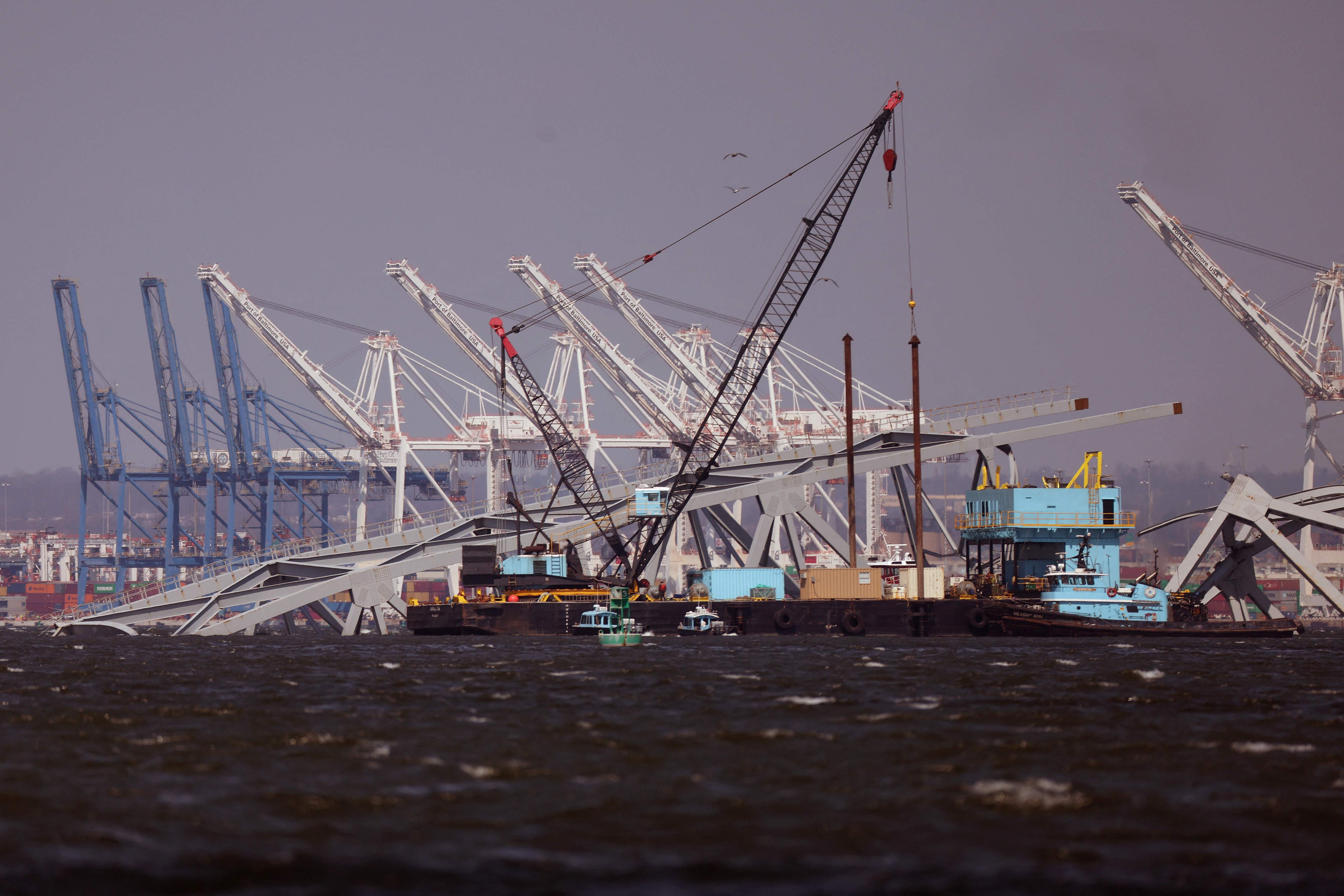 El puerto de Baltimore se ve al fondo mientras las grúas trabajan para limpiar los escombros. (Foto Prensa Libre: AFP)