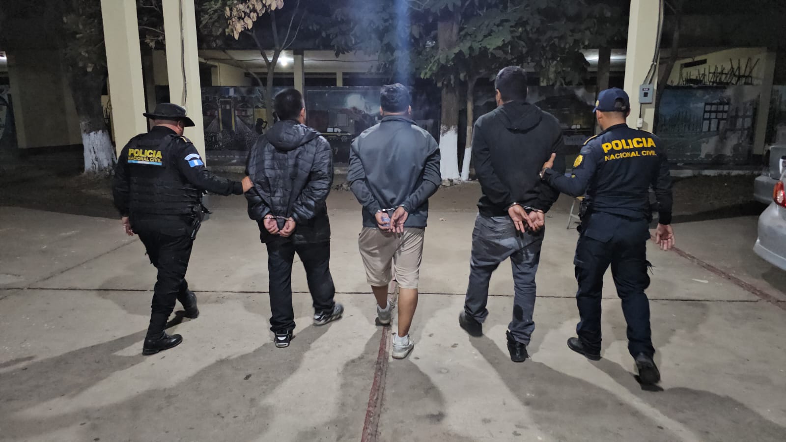 Agentes de la PNC trasladan a los tres pesuntos coyotes detenidos en Cuilapa, Santa Rosa, cuando transportaban a 51 migrantes. (Foto Prensa Libre: PNC)