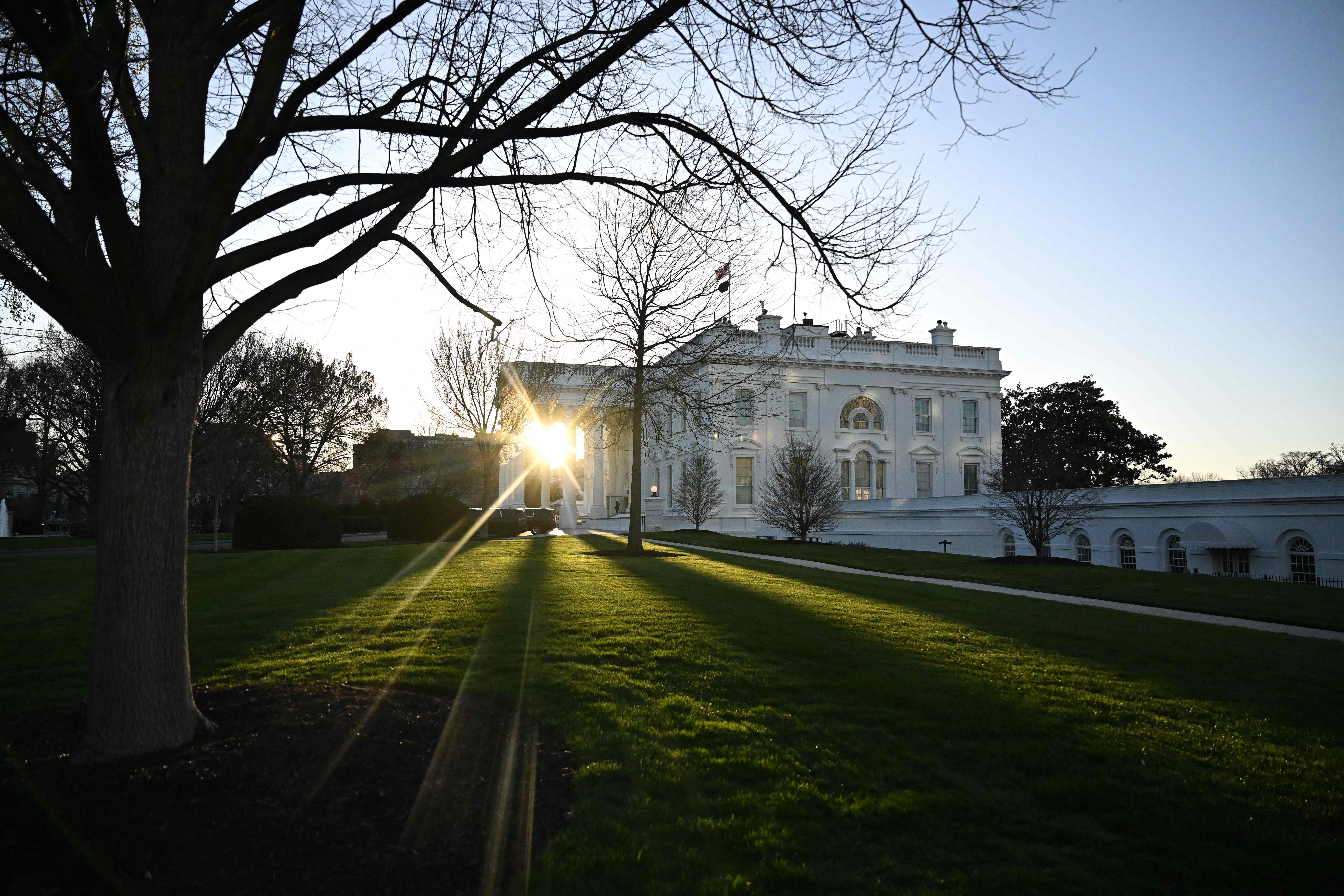 The sun rises through the North Portico of the White House in Washington, DC, on March 11, 2024. (Photo by Jim WATSON / AFP)