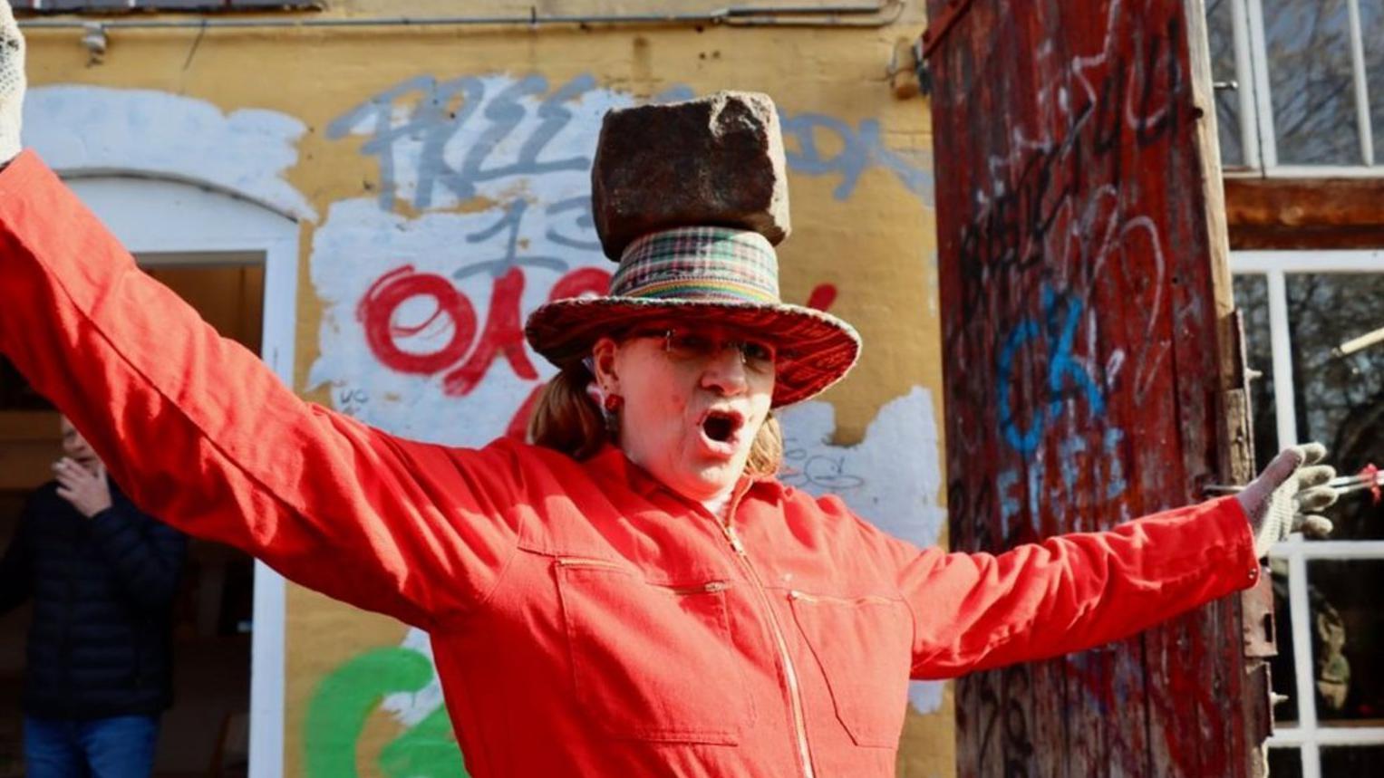 Una mujer con un adoquín de Pusher Street en su cabeza celebra el intento por recuperar el control de Christiania.

BBC