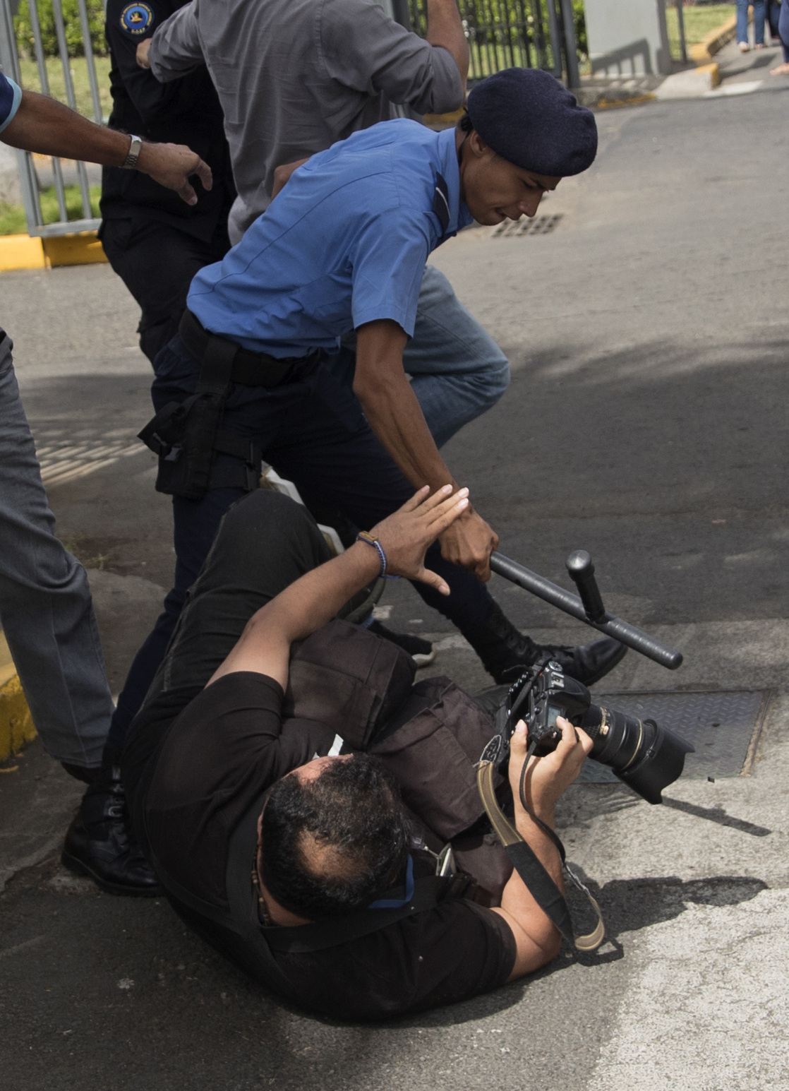 AME6293. MANAGUA (NICARAGUA), 10/04/2024.- Fotografiá de archivo del 12 de diciembre de 2019 que muestra a un agente de la policía nacional (i) que golpea al fotógrafo del diario la prensa Oscar Navarrete (c), durante una protesta en demanda de la liberación de presos políticos, en Managua (Nicaragua). Los periodistas nicaragüenses están abandonando la profesión gradualmente por la "represión" que ejerce el Gobierno que preside Daniel Ortega y por problemas financieros, alertó este miércoles la Fundación por la Libertad de Expresión y Democracia (FLED), con sede en Costa Rica. En un informe trimestral titulado 'Represión y problemas financieros forjan el camino hacia el abandono de la práctica periodística en Nicaragua', la FLED dijo que han logrado comprobar que un "número indeterminado" de periodistas han abandonado la profesión desde abril de 2018, y en la actualidad se dedican a otras labores económicas para obtener el sustento de sus familias. EFE/Jorge Torres