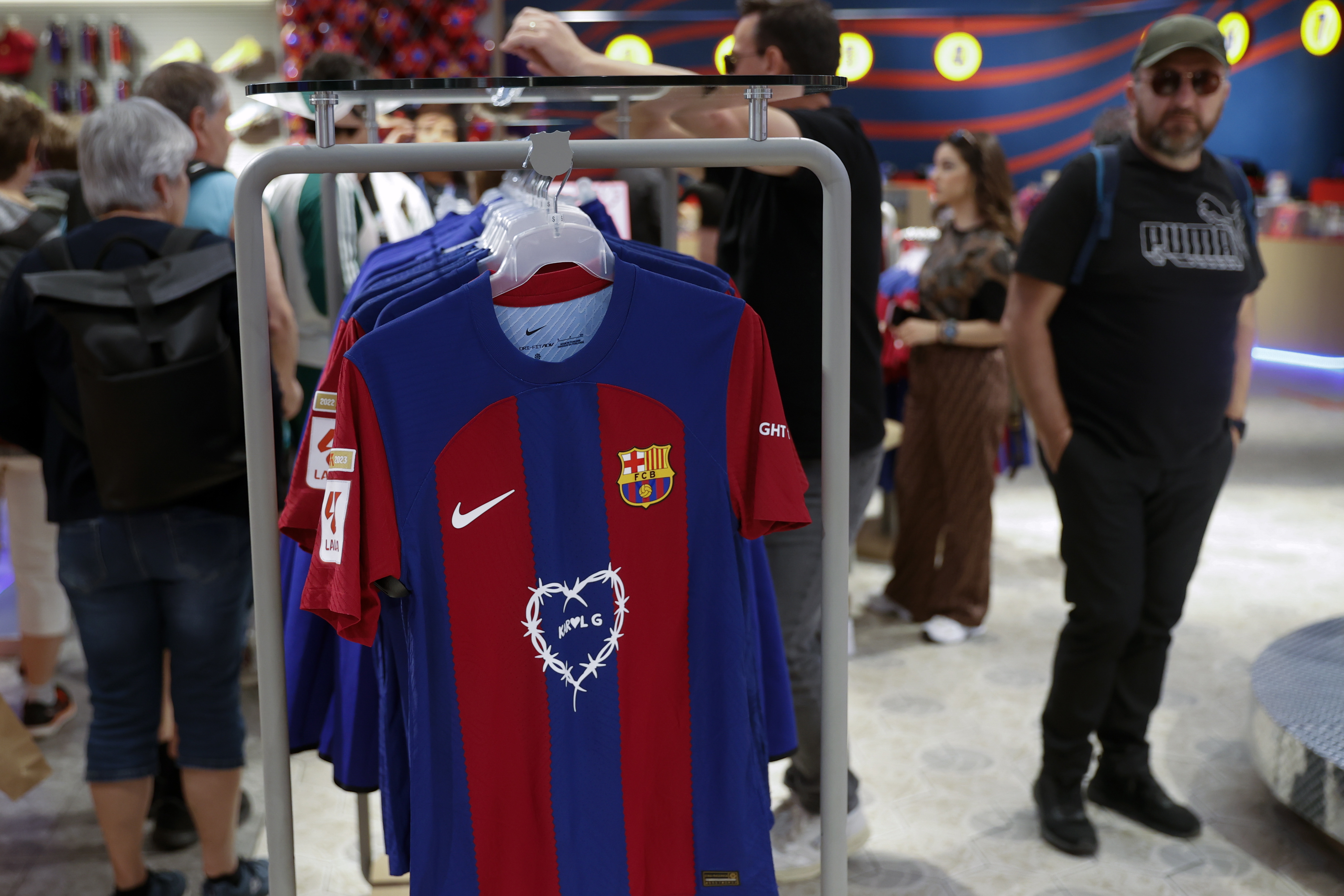 Varios clientes recorren la tienda del Barcelona de la Rambla después de que el FC Barcelona ha anunciado que el equipo lucirá el logotipo de la artista colombiana Karol G.