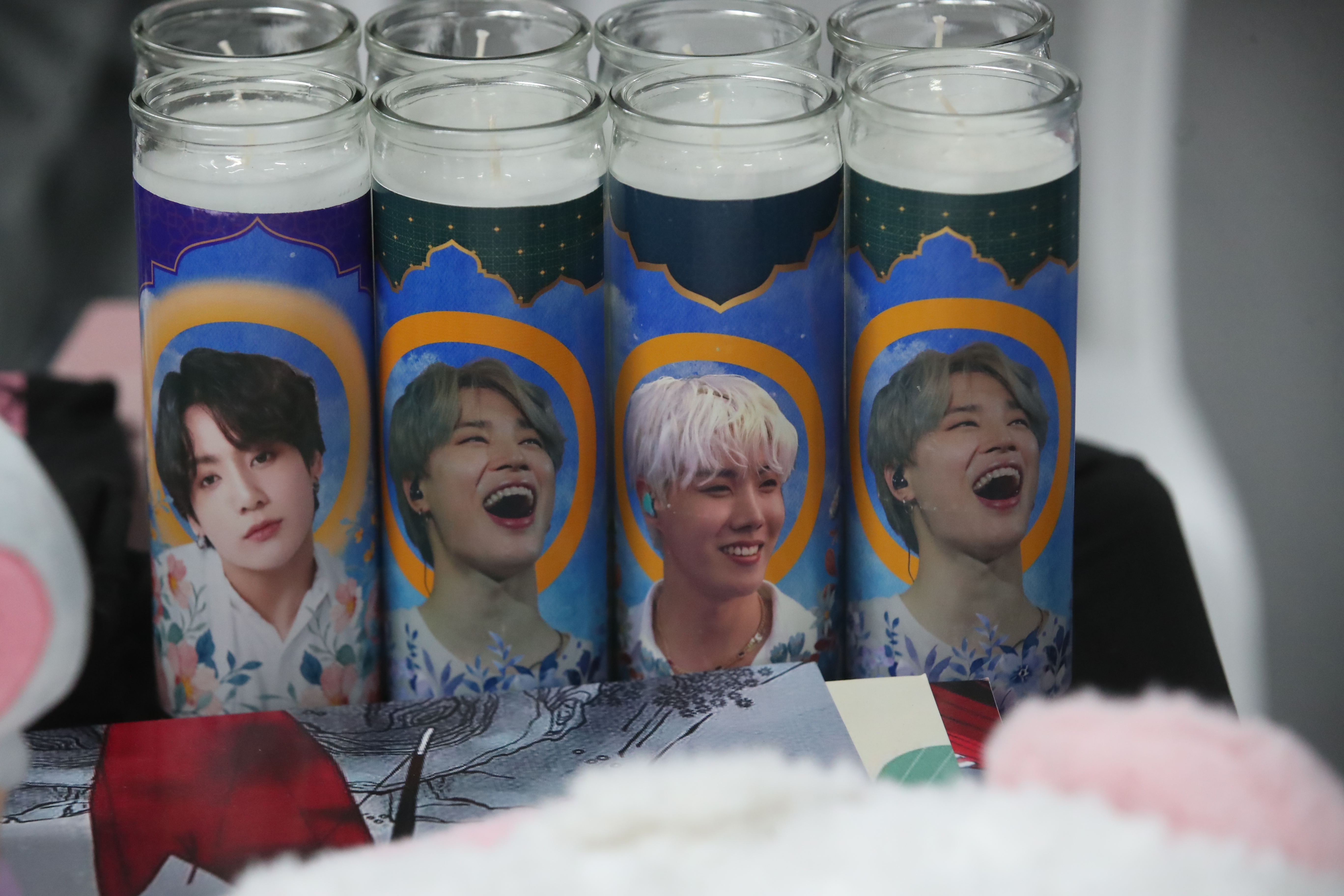 Veladoras curiosas con imágenes de artistas icónicos del K-Pop iluminan el ambiente del K-Day, destacando la devoción y admiración de los fanáticos por sus ídolos. (Fotografía Prensa Libre: Byron Rivera Baiza).