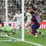El portero del Real Madrid, Andriy Lunin, ataja el balón de la polémica tras un disparo del jugador del Barcelona, Lamine Yamal. (Foto Prensa Libre: AFP)