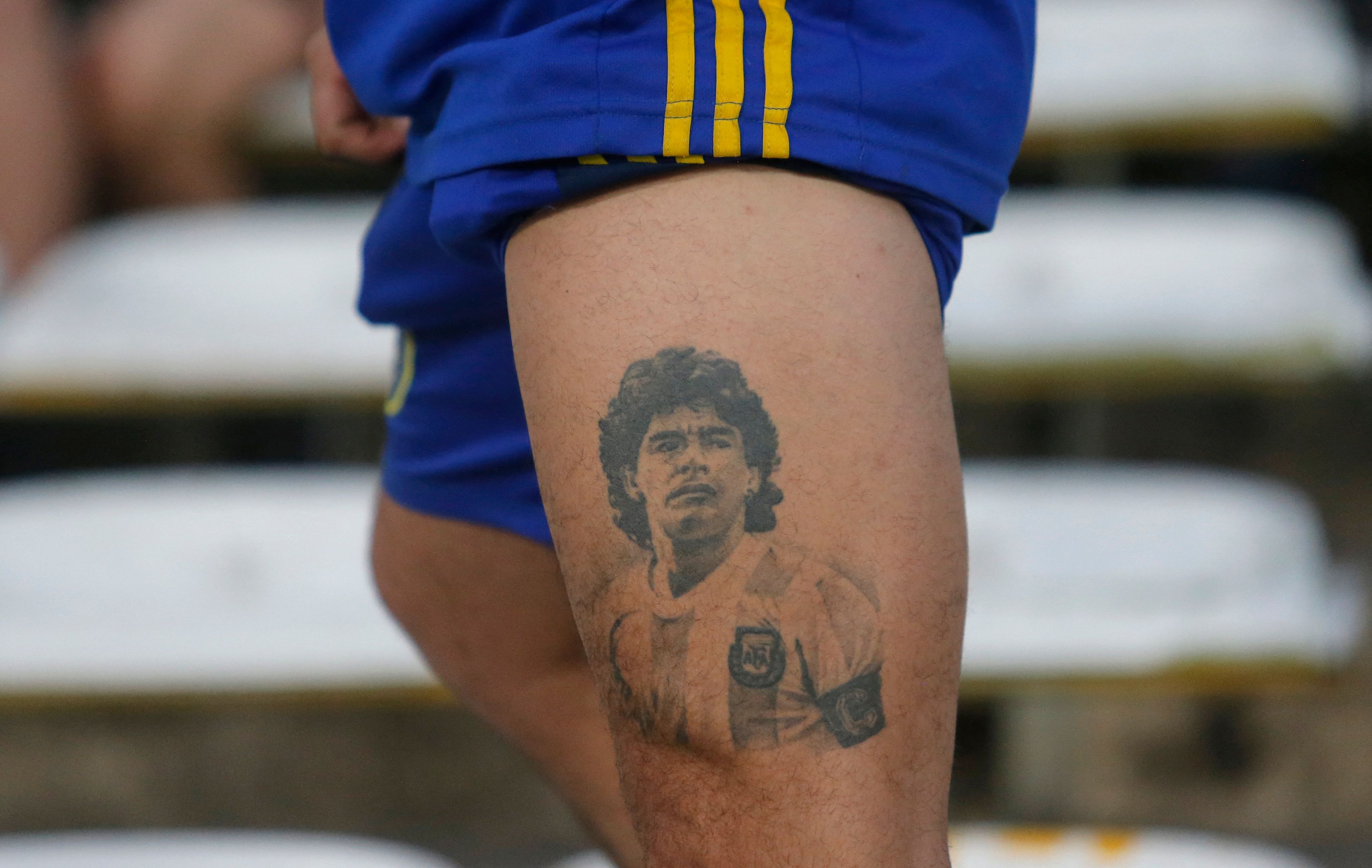 Aficionado de Boca muestra un tatuaje de Diego Maradona.