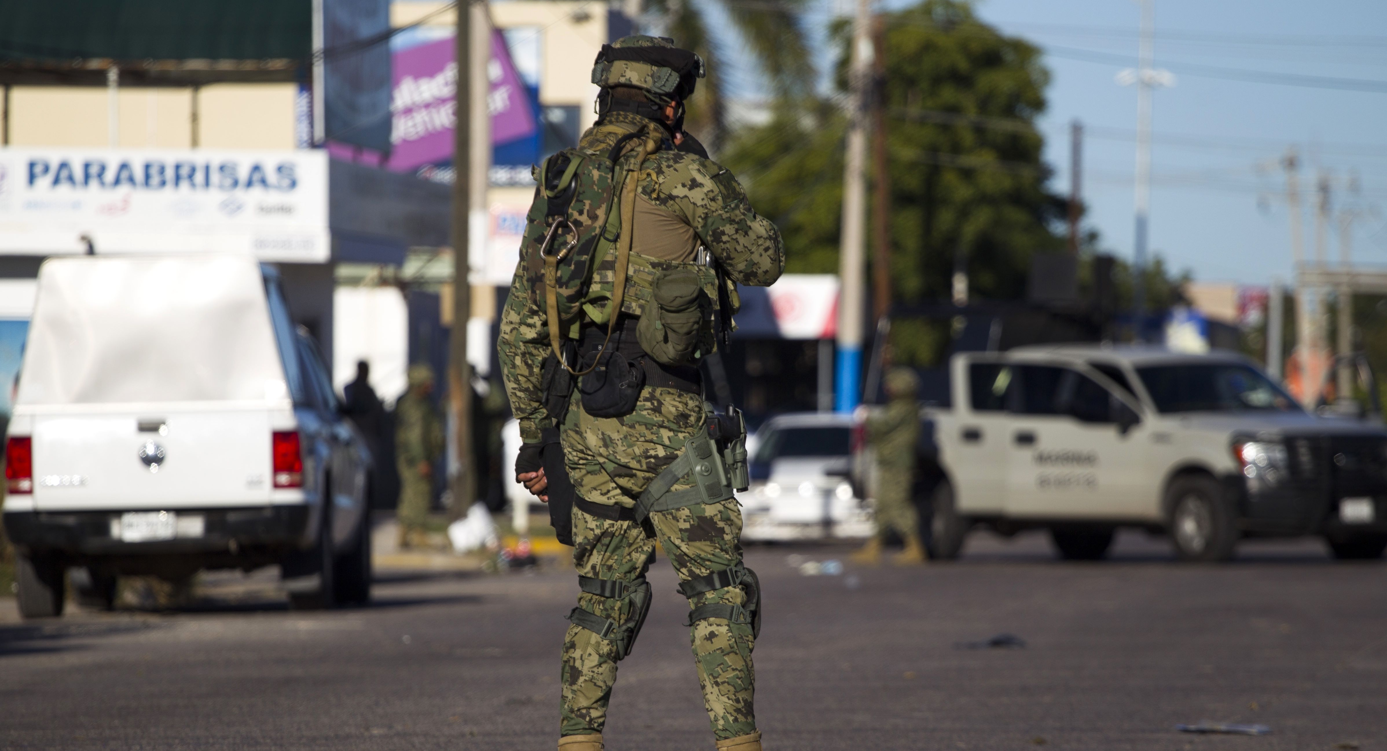 A marine stands guard on January 9, 2016 on the street in front of the house where five gang suspects were killed in the military operation which resulted in the recapture of Joaquin "El Chapo" Guzman in the city of Los Mochis, Sinaloa State, Mexico. Mexican marines recaptured fugitive drug kingpin Joaquin "El Chapo" Guzman on January 8 in the northwest of the country, six months after his spectacular prison break embarrassed authorities. AFP PHOTO / HECTOR GUERRERO