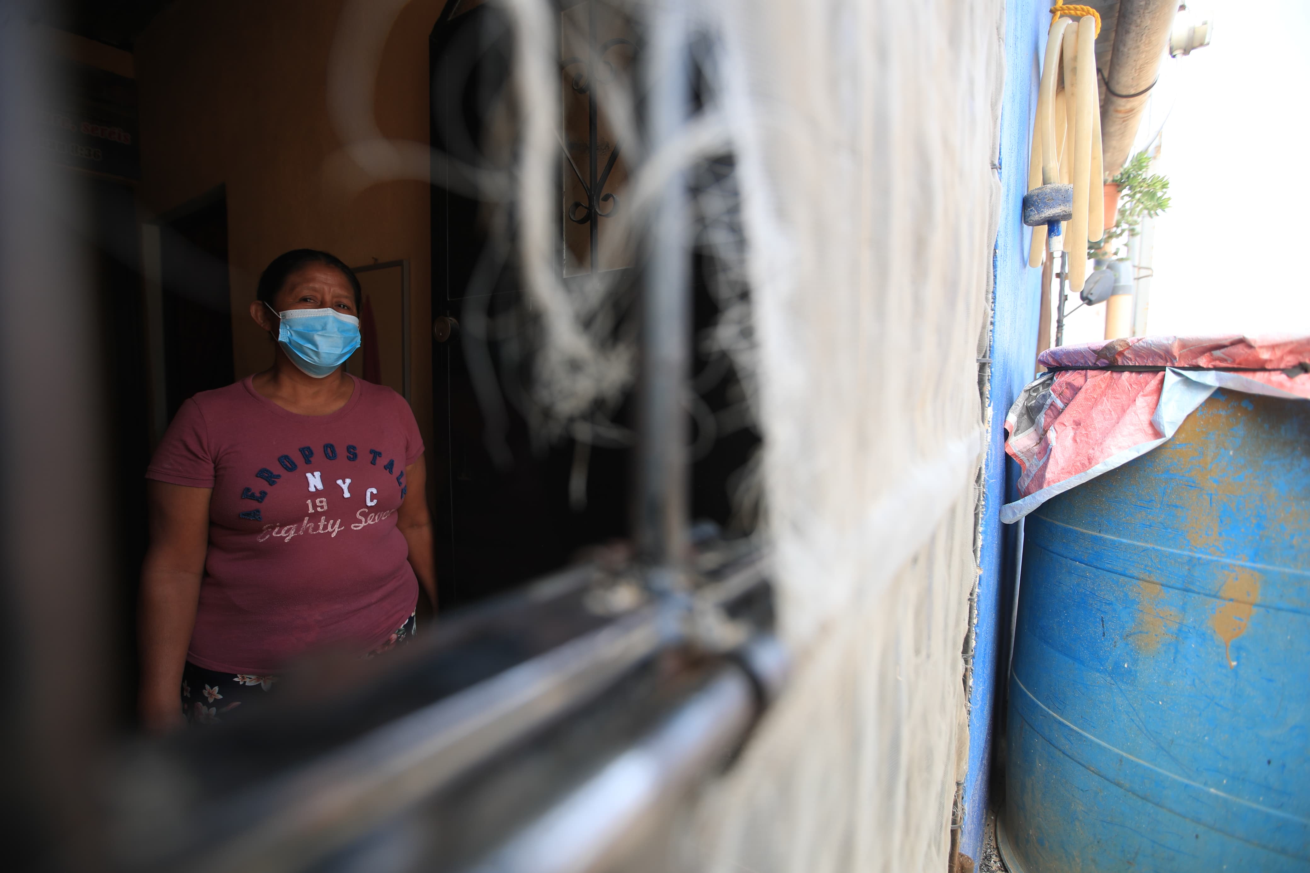 Vecinos de la colonia Alta Mira, cercana al vertedero, mantienen sus ventanas y puertas cerradas para evitar el humo y el olor provocado por el incendio. El uso de mascarilla es una medida para evitar problemas respiratorios. (Foto Prensa Libre: Carlos Hernández Ovalle)