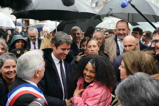 French Prime Minister Gabriel Attal (2ndL), escorted by Beaugency mayor Jacques Mesas (L) meets with residents during a visit to Beaugency in the Loiret department, to discuss the revitalisation and attractiveness of small towns, on May 1, 2024. (Photo by Dimitar DILKOFF / AFP)