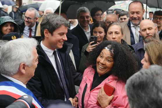 French Prime Minister Gabriel Attal (2ndL), escorted by Beaugency mayor Jacques Mesas (L) meets with residents during a visit to Beaugency in the Loiret department, to discuss the revitalisation and attractiveness of small towns, on May 1, 2024. (Photo by Dimitar DILKOFF / AFP)
