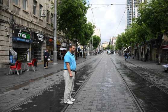 A man stands observes a minute of silence in the centre of Jerusalem as sirens blared across Israel on May 6, 2024 bringing it to a standstill to mark the annual day of remembrance for the six million Jewish victims of the Nazi genocide. (Photo by RONALDO SCHEMIDT / AFP)