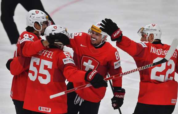 Switzerland's forward #85 Sven Andrighetto (C) celebrates with teammates after scoring during the IIHF Ice Hockey Men's World Championships match between Switzerland and Norway in Prague, Czech Republic on May 10, 2024. (Photo by Michal Cizek / AFP)