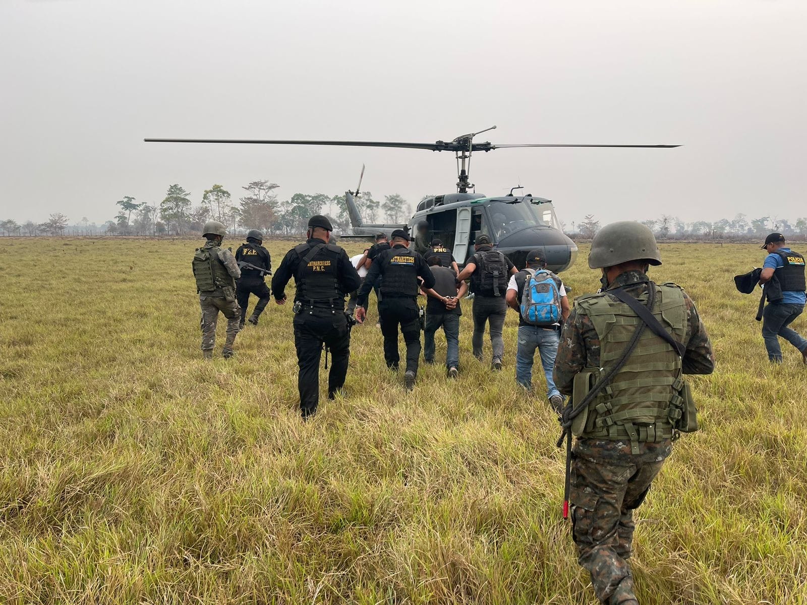 Dos hombres capturados en Petén son trasladados a la capital vía aérea. (Foto Prensa Libre: PNC)