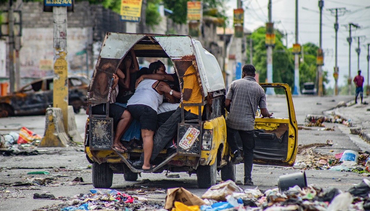Pobladores se transportan en un automóvil con sus pertenencias después de un ataque de bandas armadas en el sector de Delmas 22, en Puerto Príncipe, Haití. (Foto Prensa Libre: EFE)