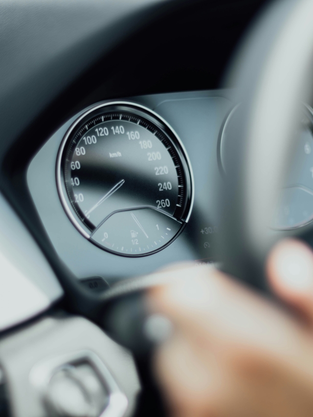 volante de un automóvil y se visualiza parte de una mano sobre el volante