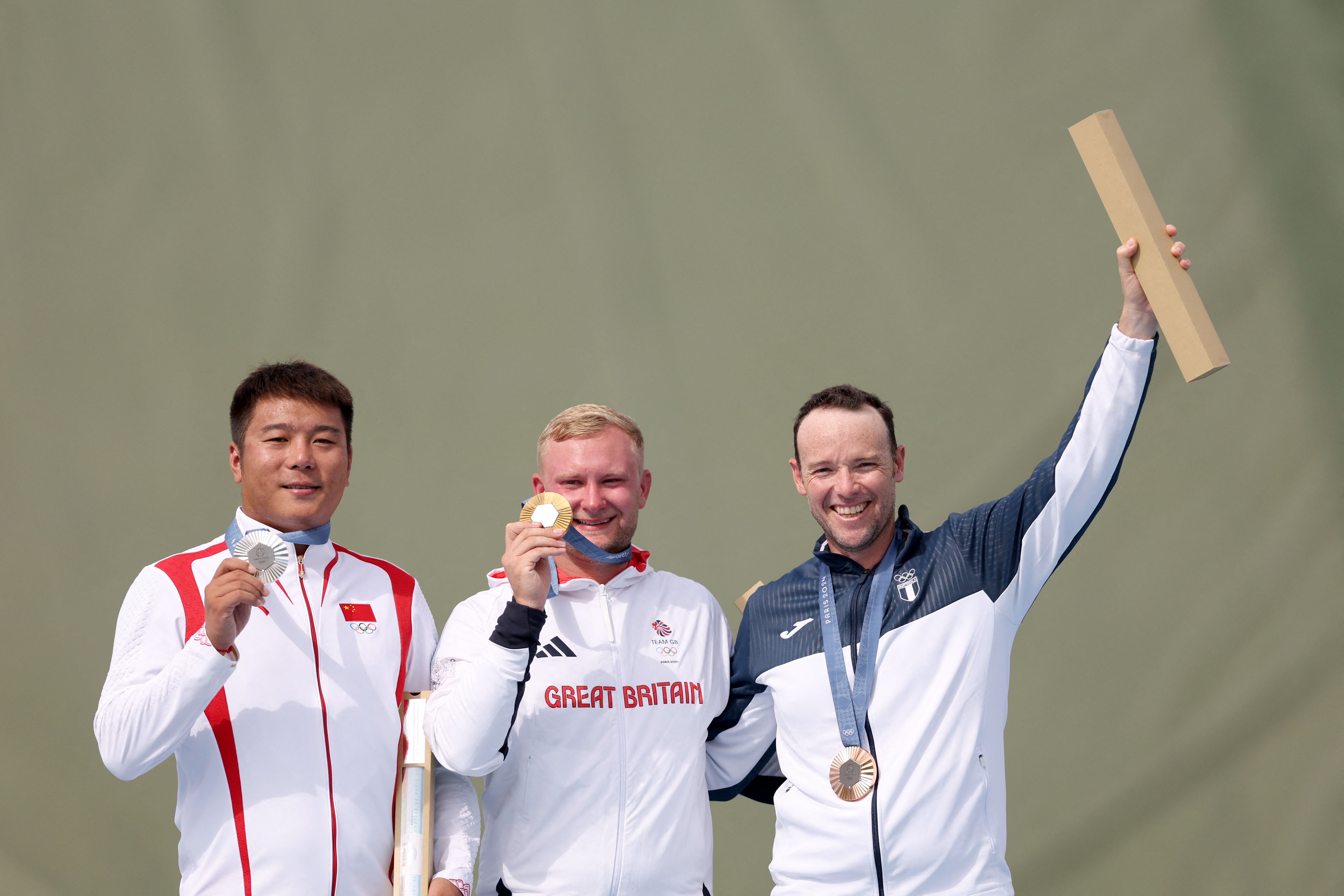 El medallista de plata Qi Ying de China, el medallista de oro Nathan Hales de Gran Bretaña y el medallista de bronce Jean Pierre Brol Cárdenas de Guatemala posan en el podio en los Juegos Olímpicos de París 2024 en el Centro de Tiro de Chateauroux. (Foto Prensa Libre: AFP