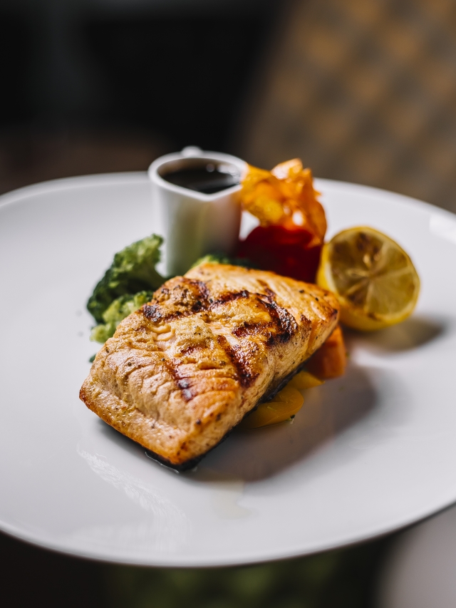 grilled fish carrot broccoli lemon pomegranate side view