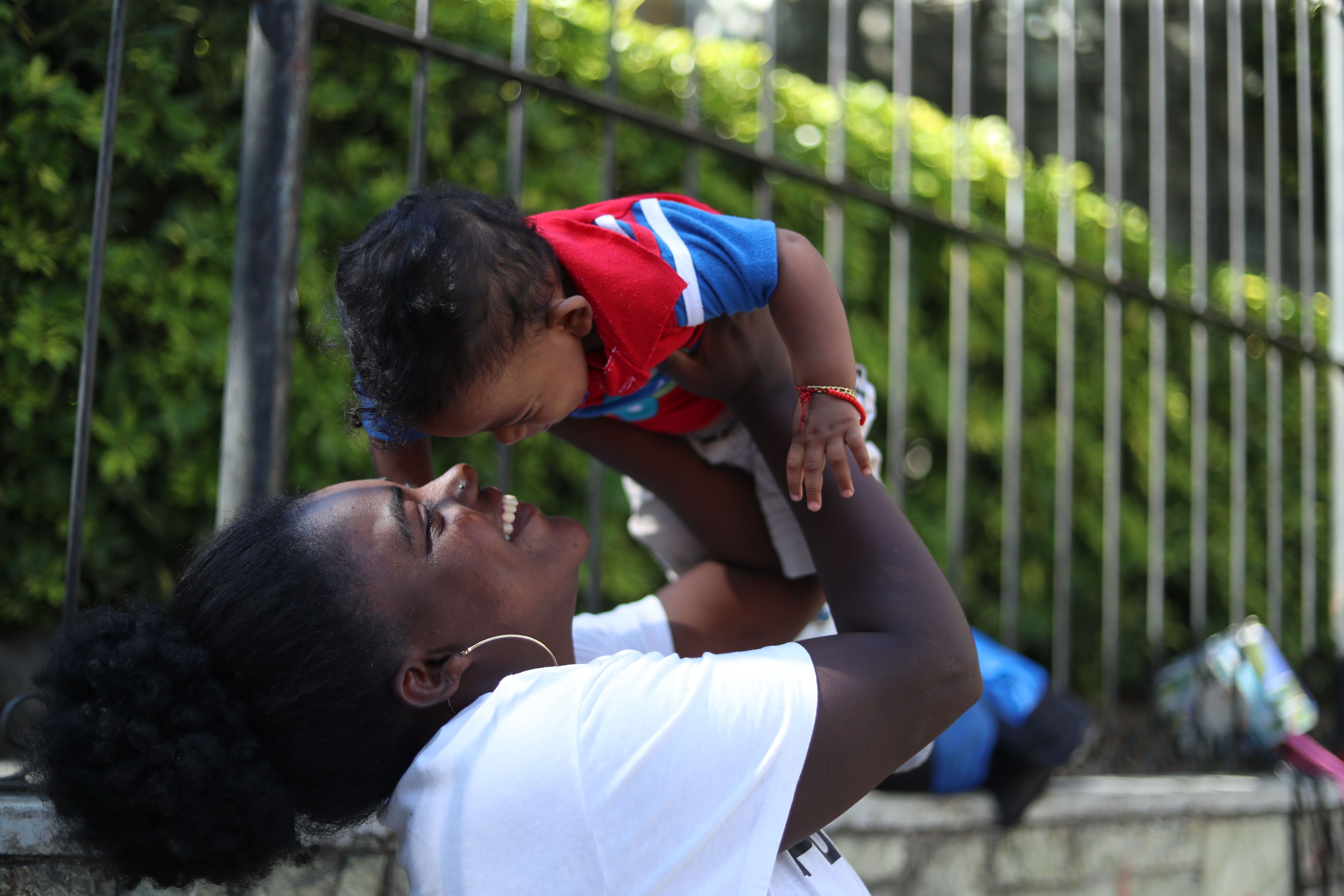 Reyna Núñez, alza en brazos a su sobrino de un año y seis meses mientras esperan la llegada de clientes. (Foto Prensa Libre: Esbin García)