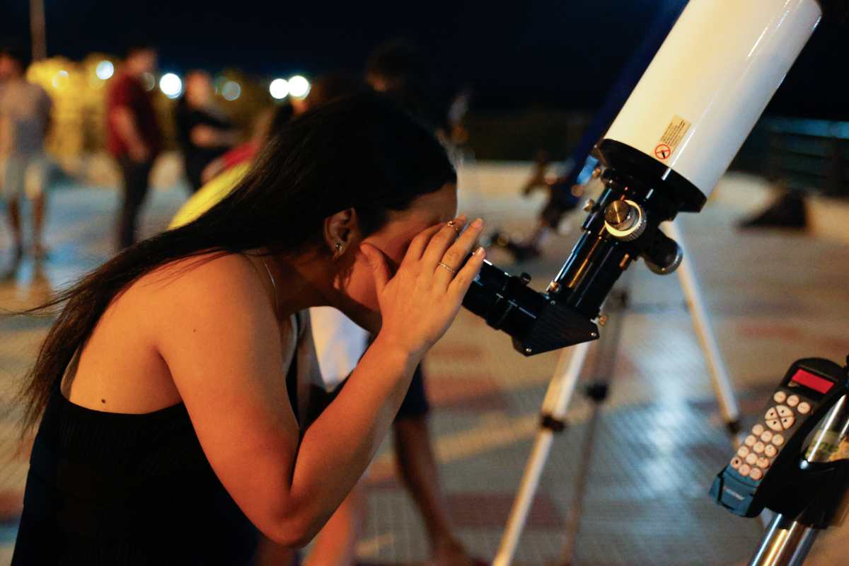 AME615. ASUNCIÓN (PARAGUAY), 17/09/2024.- Una mujer observa por un telescopio el eclipse lunar parcial este martes, en Asunción (Paraguay). EFE/ Juan Pablo Pino