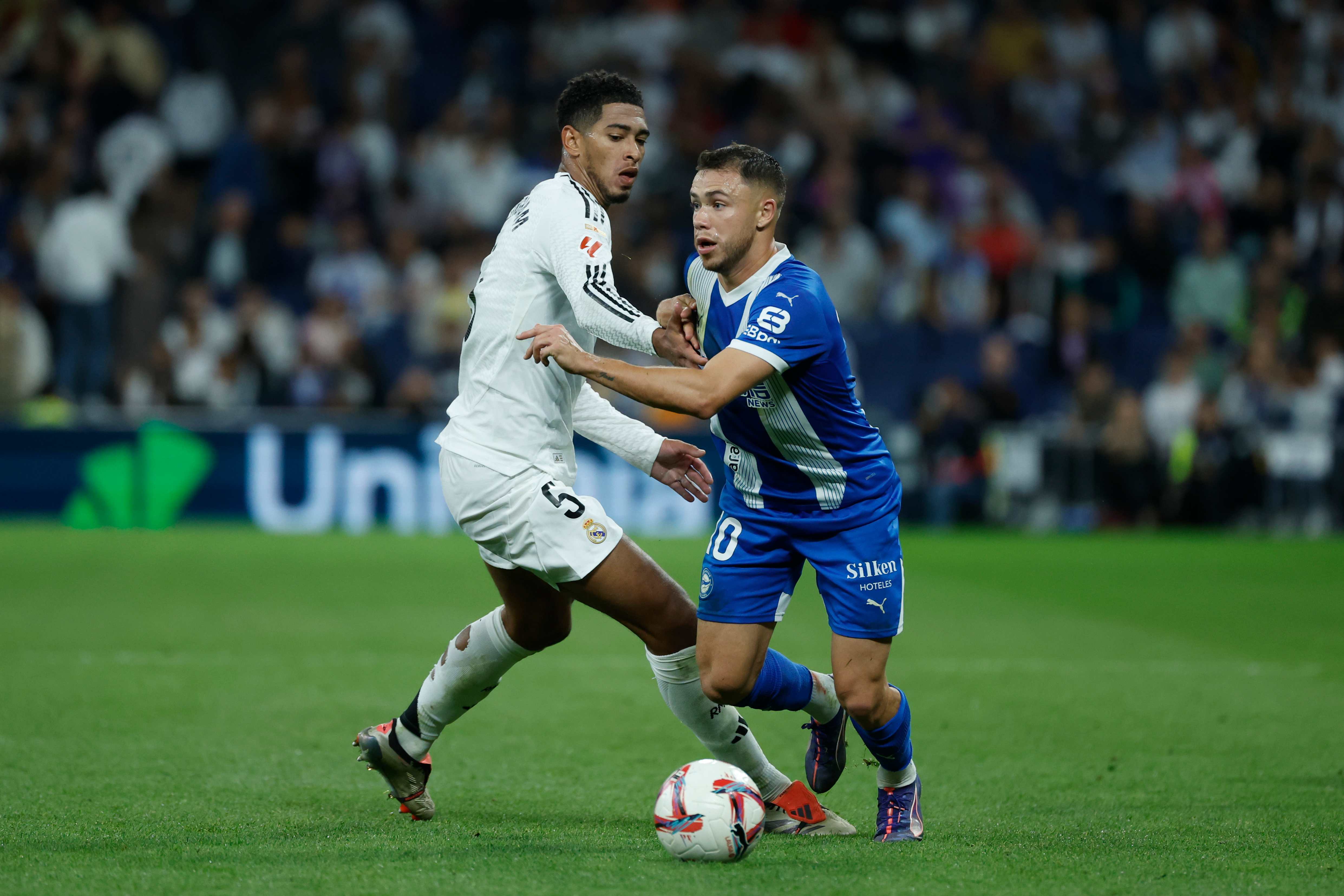 Alavés's Argentine striker Tomás Conechny (D), takes the ball before Real Madrid's English midfielder, Jude Bellingham.
