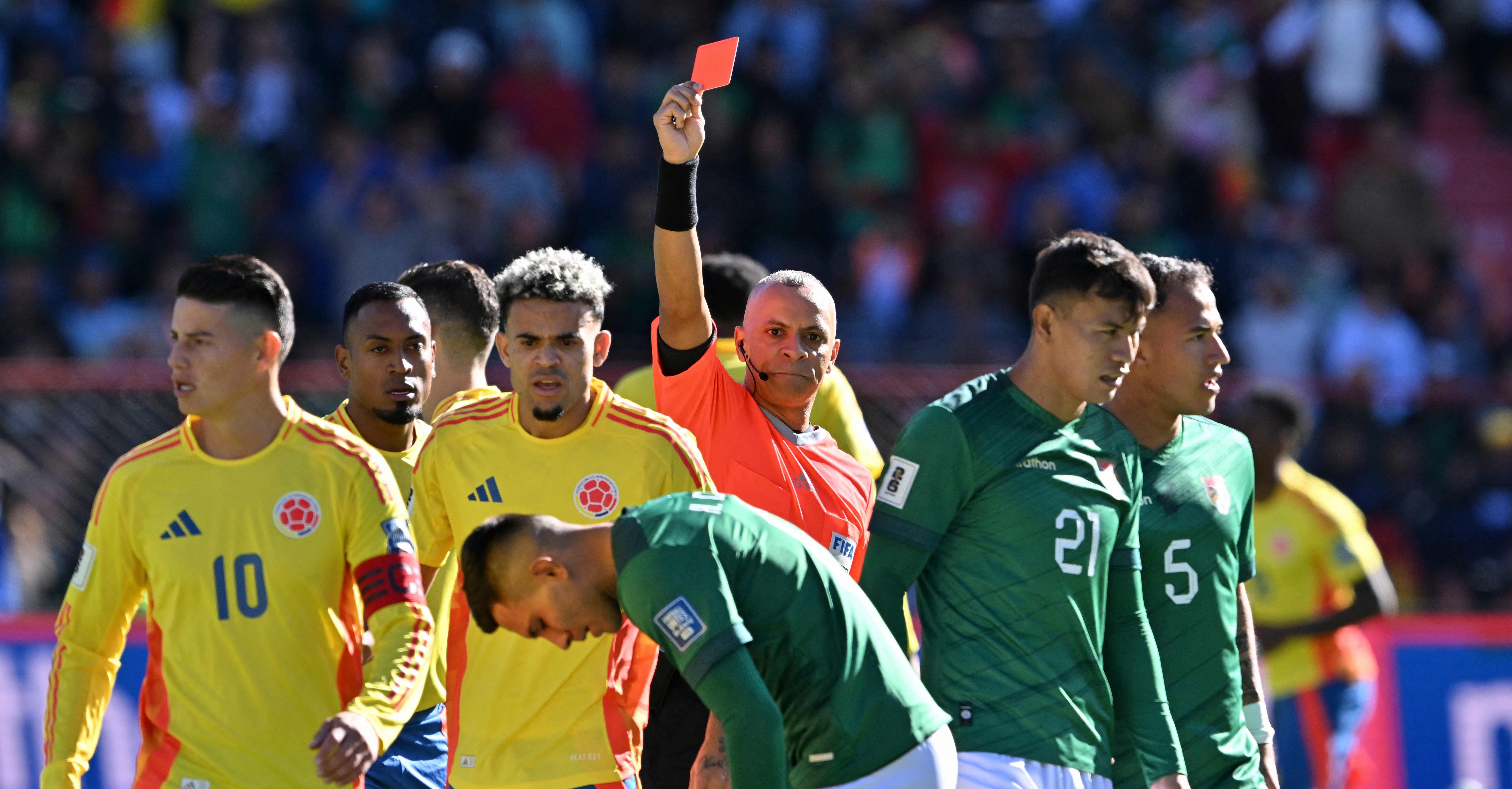 Brazilian referee Wilton Pereira Sampaio (C-back) shows a red card to Bolivia's defender Hector Cuellar (C) during the 2026 FIFA World Cup South American qualifiers football match between Bolivia and Colombia, at the Municipal stadium in El Alto, Bolivia on October 10, 2024. (Photo by AIZAR RALDES / AFP)