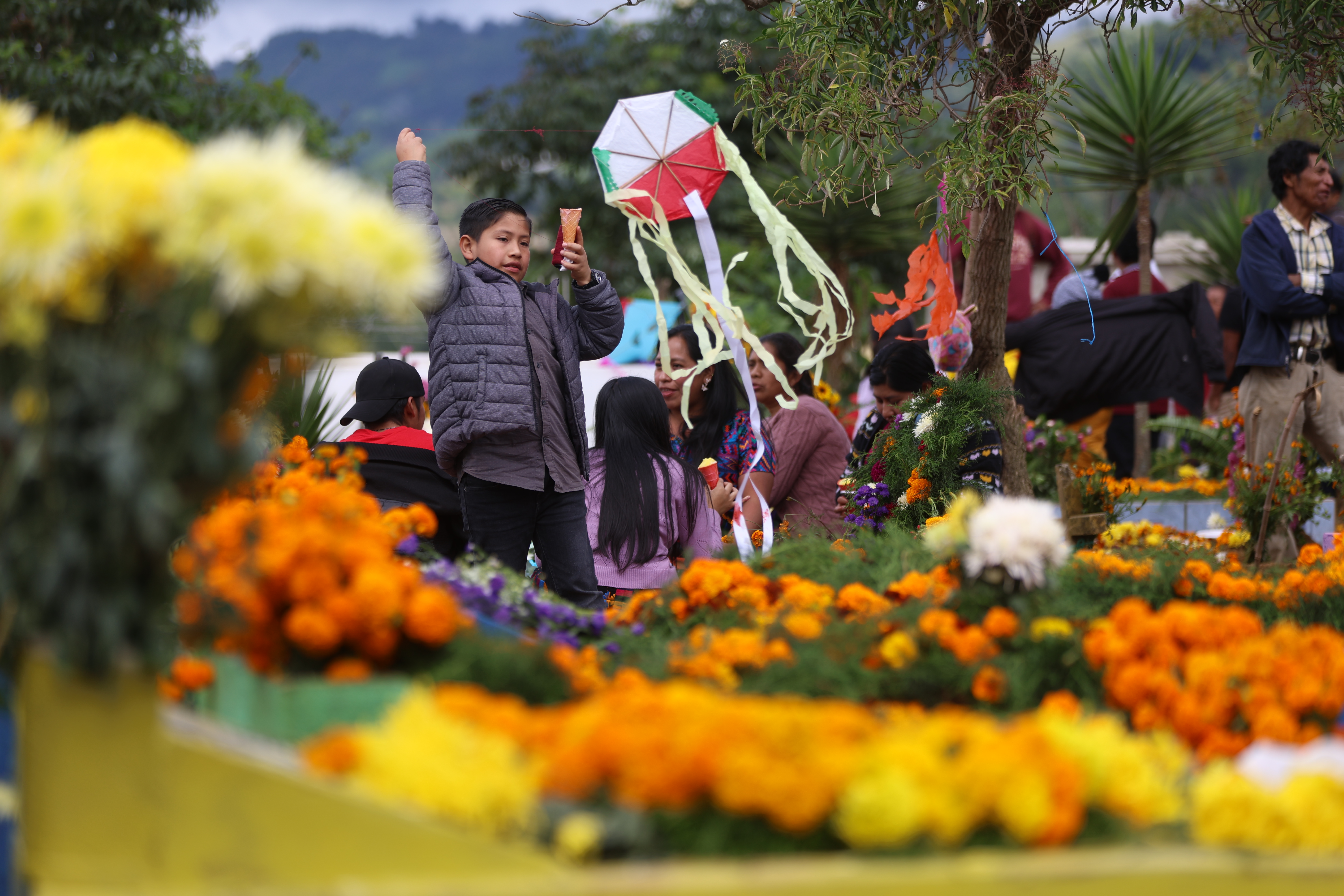 -FOTODELDÍA- AME3806. CIUDAD DE GUATEMALA (GUATEMALA), 01/11/2024.- Personas se reúnen en el Cementerio General de Santiago Sacatepéquez este viernes, en Ciudad de Guatemala (Guatemala). Inicia la tradicional exhibición de cometas (barriletes) gigantes a 36 kilómetros de la ciudad, en el Día de Muertos en Guatemala. EFE/ Mariano Macz