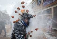 Revellers dressed in mock military garb take part in "Els Enfarinats" flour-battle in the southeastern Spanish town of Ibi on December 28, 2024. In this 200-year-old traditional winter festival, the participants --known as Els Enfarinats (those covered in flour)-- dress in military clothes and stage a mock coup d'etat as they battle using flour, eggs and firecrackers outside the town hall as part of the celebrations of the Day of the Innocents, a traditional day in Spain for pulling pranks. (Photo by JAIME REINA / AFP)