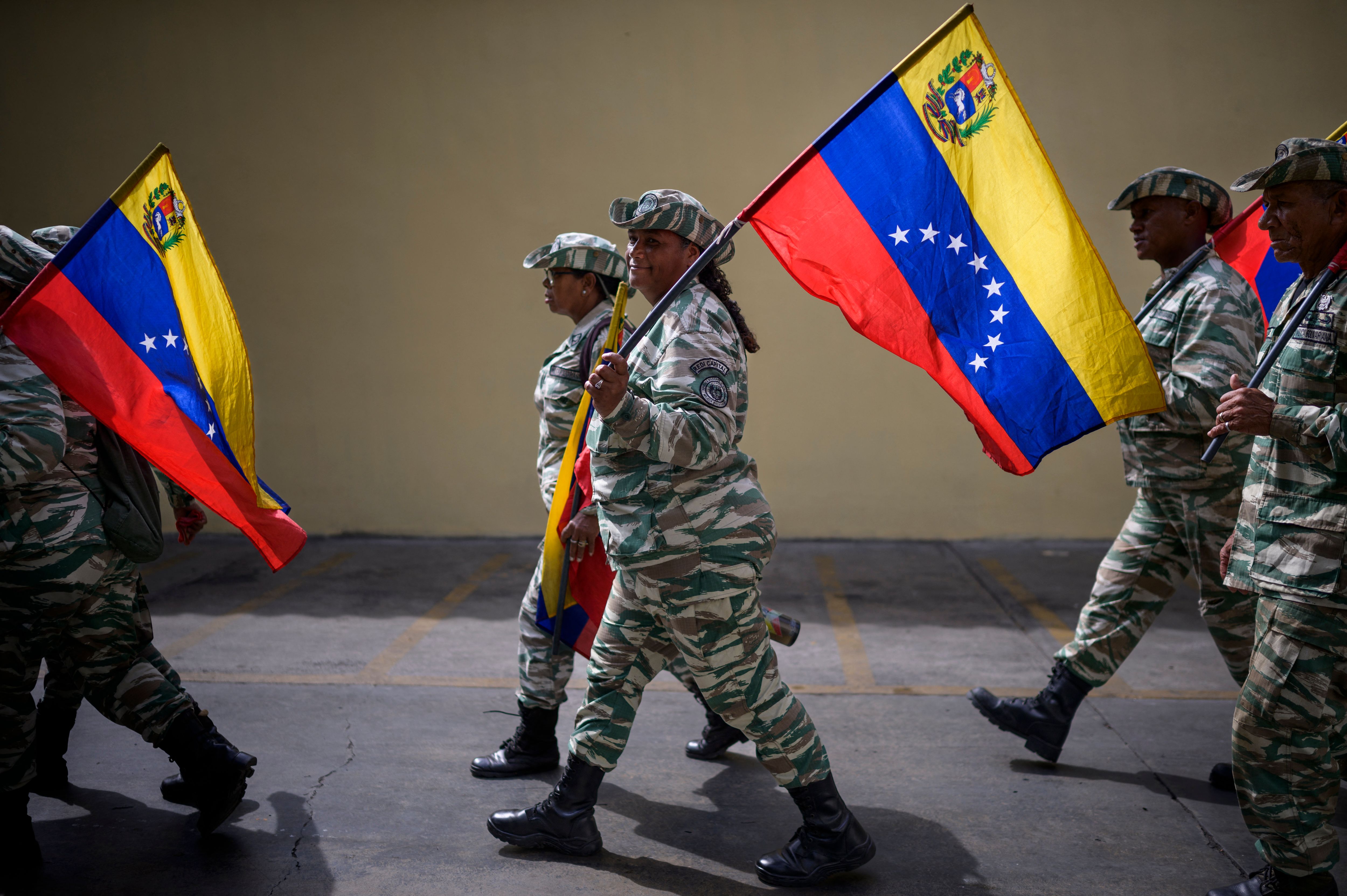 Miembros de la Milicia Bolivariana caminan con banderas venezolanas cerca del Palacio Federal Legislativo durante la instalación del Parlamento Nacional en Caracas. (Foto Prensa Libre: AFP)