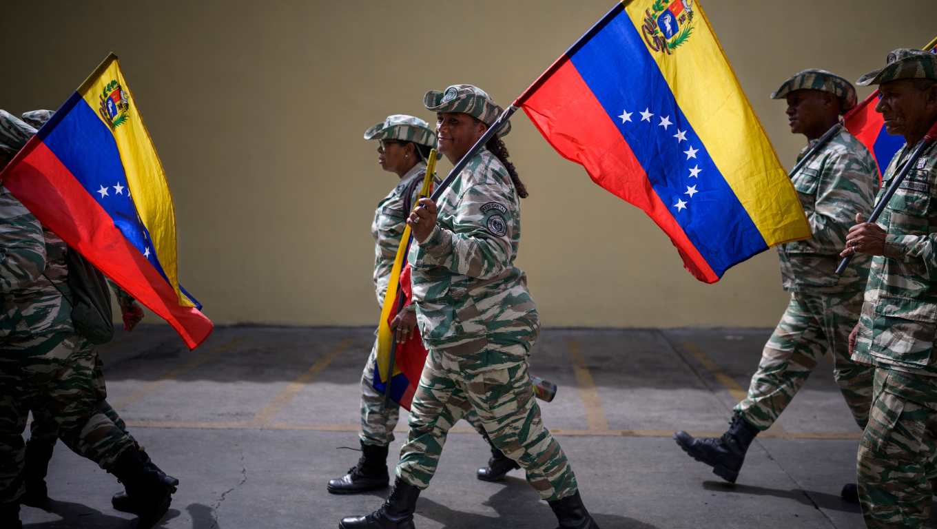 Miembros de la Milicia Bolivariana caminan con banderas venezolanas cerca del Palacio Federal Legislativo durante la instalación del Parlamento Nacional en Caracas. (Foto Prensa Libre: AFP)