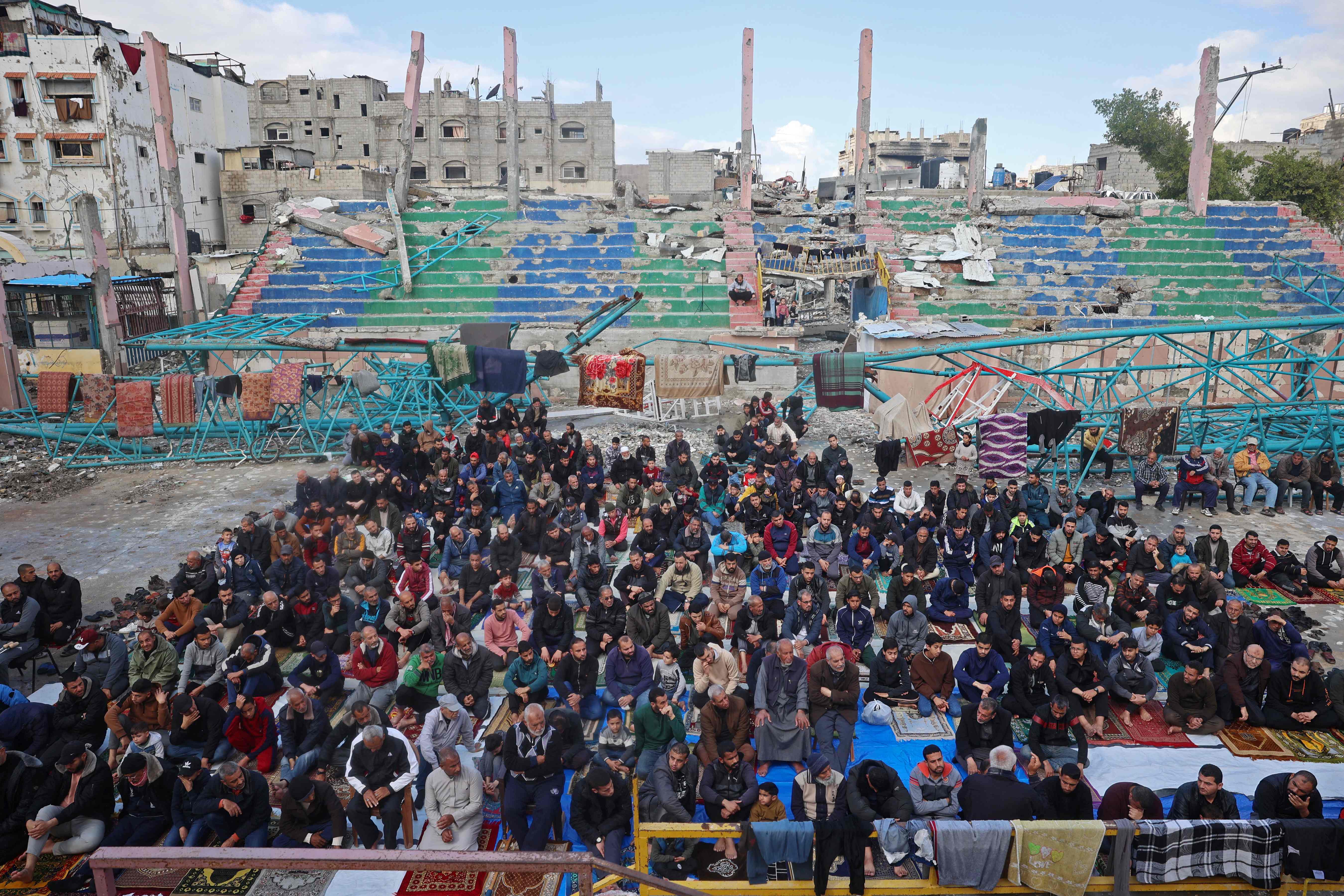 Devotos ofrecen oraciones en un campamento para palestinos desplazados en Bureij, en el centro de la Franja de Gaza. (Foto Prensa Libre: AFP)