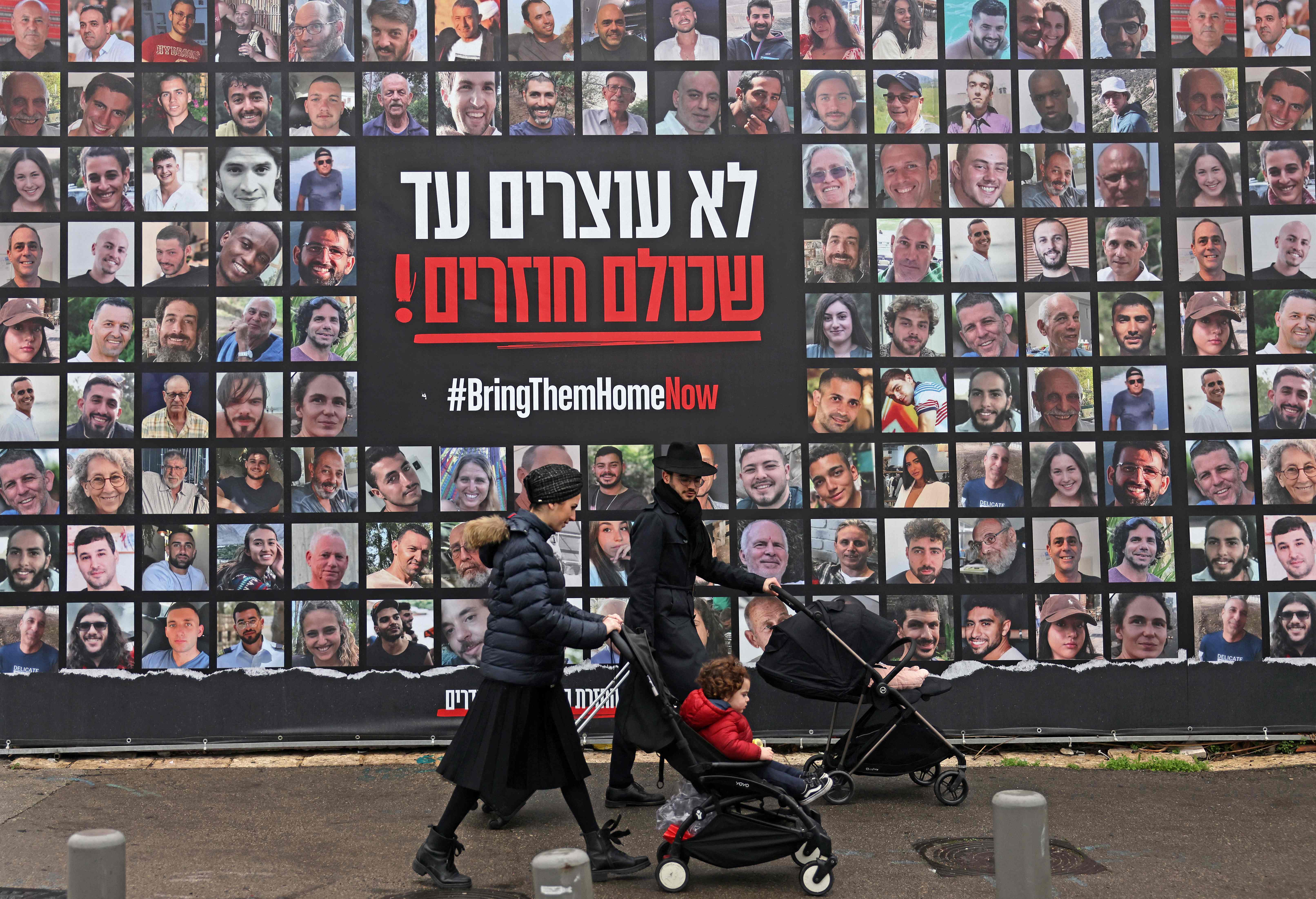 Peatones pasan junto a los retratos de rehenes israelíes retenidos en la Franja de Gaza desde los ataques del 7 de octubre de 2023 perpetrados por militantes de Hamás, en Jerusalén. (Foto Prensa Libre: AFP)