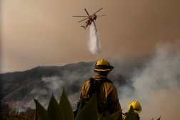 LOS ANGELES, CALIFORNIA - JANUARY 11: A firefighting helicopter drops water on the Palisades Fire on January 10, 2025 in Los Angeles, California. The Palisades fire had grown to over 22,000 acres and has destroyed thousands of homes. The fire is currently 11 percent contained.   Justin Sullivan/Getty Images/AFP (Photo by JUSTIN SULLIVAN / GETTY IMAGES NORTH AMERICA / Getty Images via AFP)