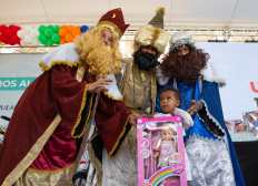 AME8730. SANTO DOMINGO (REPÚBLICA DOMINICANA), 05/01/2025.- Una niña posa junto a los Reyes Magos durante la quinta edición de la jornada 'Plásticos por Juguetes' este domingo, en Santo Domingo (República Dominicana). La actividad se desarrolla en el marco del Día de Reyes y en ella se cambian botellas plásticas por juguetes, que en las anteriores ediciones ha recolectado más de 14 millones de botellas. EFE/ Orlando Barría