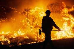 CASTAIC, CALIFORNIA - JANUARY 22: (EDITOR'S NOTE: Alternate crop) A firefighter works as the Hughes Fire burns on January 22, 2025 in Castaic, California. The wildfire has spread 9,400 acres and has prompted mandatory evacuations just over two weeks after the Eaton and Palisades Fires caused widespread destruction across Los Angeles County.   Brandon Bell/Getty Images/AFP (Photo by Brandon Bell / GETTY IMAGES NORTH AMERICA / Getty Images via AFP)