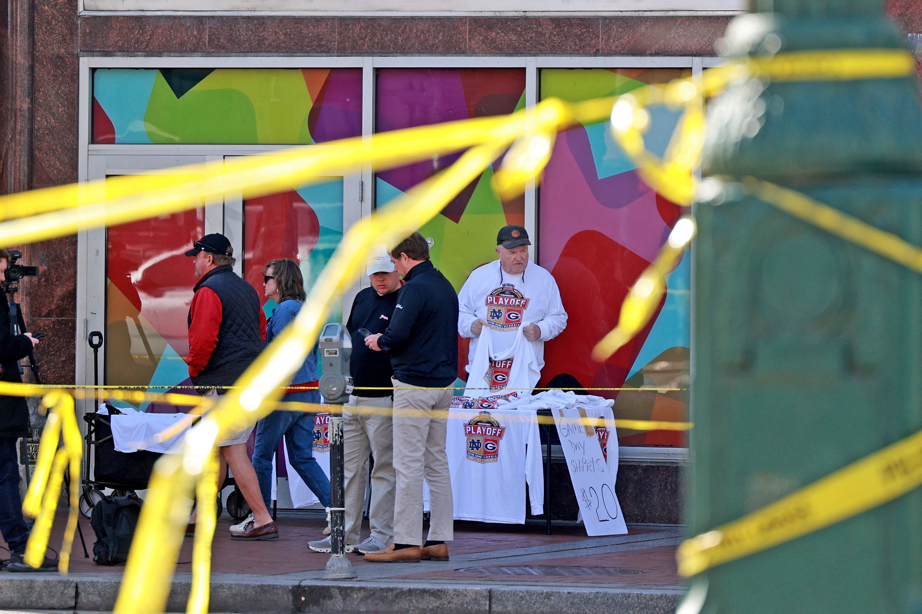 Un vendedor ofrece camisetas del Sugar Bowl en medio de una cinta policial en Canal Street y Bourbon Street antes del juego el  dos de enero. (Foto Prensa Libre: AFP)