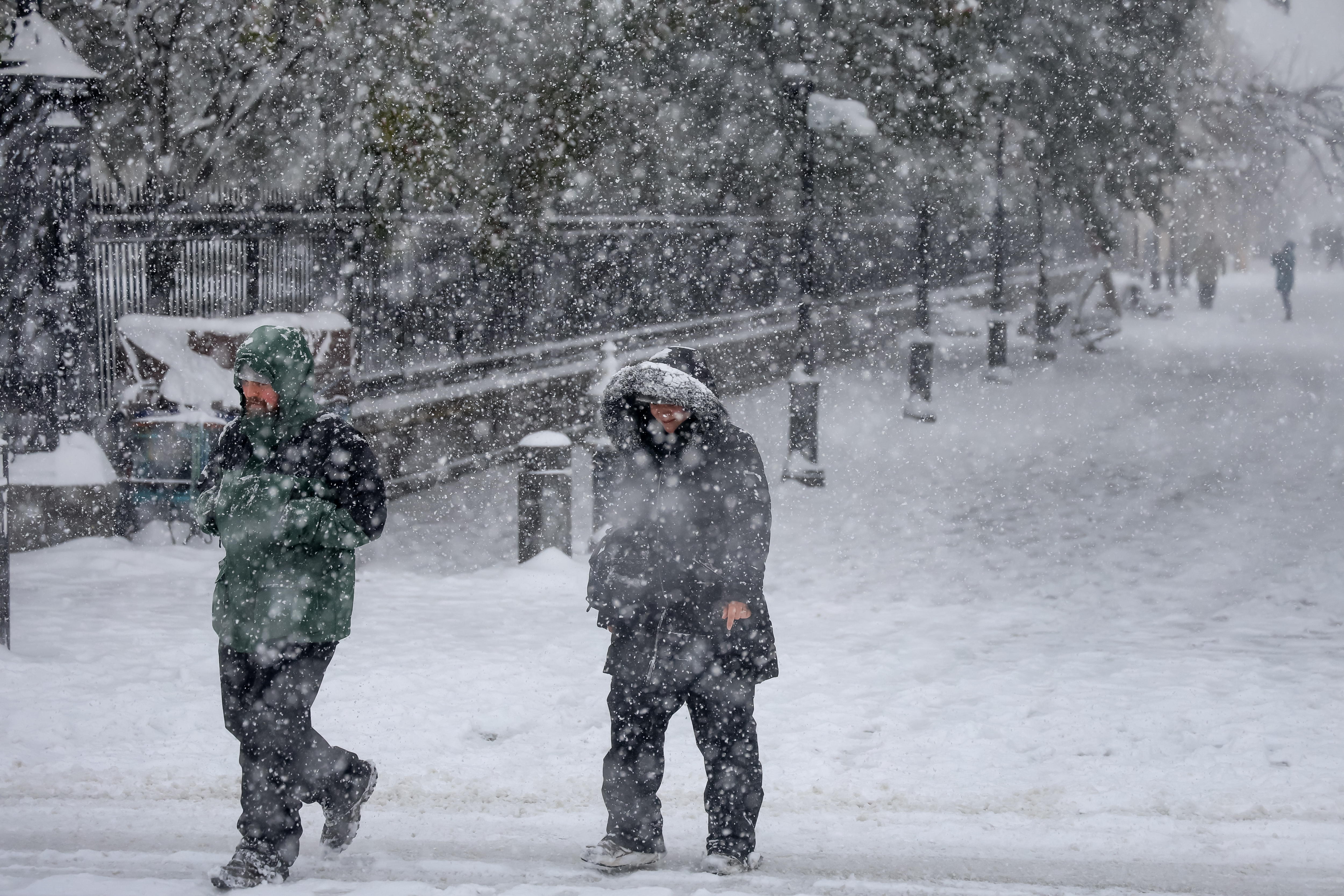 Sin importar la intensa tormenta invernal, personas caminan en el barrio francés cubierto de nieve. (Foto Prensa Libre: EFE)