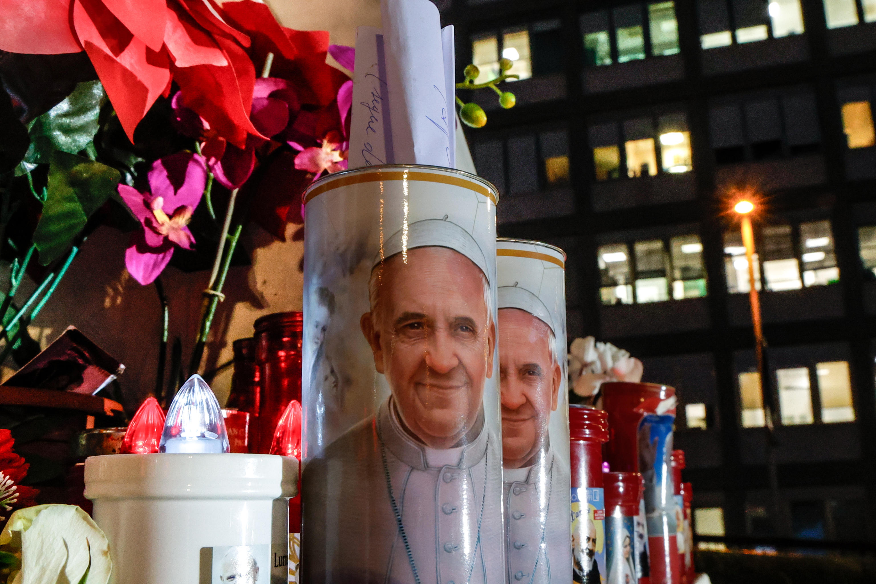 El Papa Francisco se encuentra interno en el Hospital Gemelli, a las afueras se encuentra la estatua de Juan Pablo II, donde cientos de feligreses colocan velas. (Foto Prensa Libre: AFP)