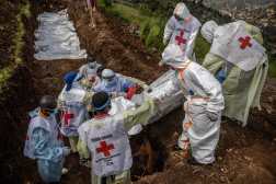 TOPSHOT - Members of the Congolese Red Cross carry body bags containing human remains during a mass burial for victims of the clashes in eastern Democratic Republic of Congo at Musigiko cemetery in Bukavu on February 20, 2025. The army of the Democratic Republic of Congo (DRC) on February 20, 2025 urged on local airwaves the soldiers fleeing in the eastern province of North Kivu to rejoin their units and continue the fight to counter the advance of the M23 rebels. In Lubero, a town towards which the M23 is advancing, 250 km north of the provincial capital Goma, taken on January 28, terrified residents reported to AFP Congolese soldiers in disarray shooting in the town and engaging in looting. (Photo by Luis TATO / AFP)