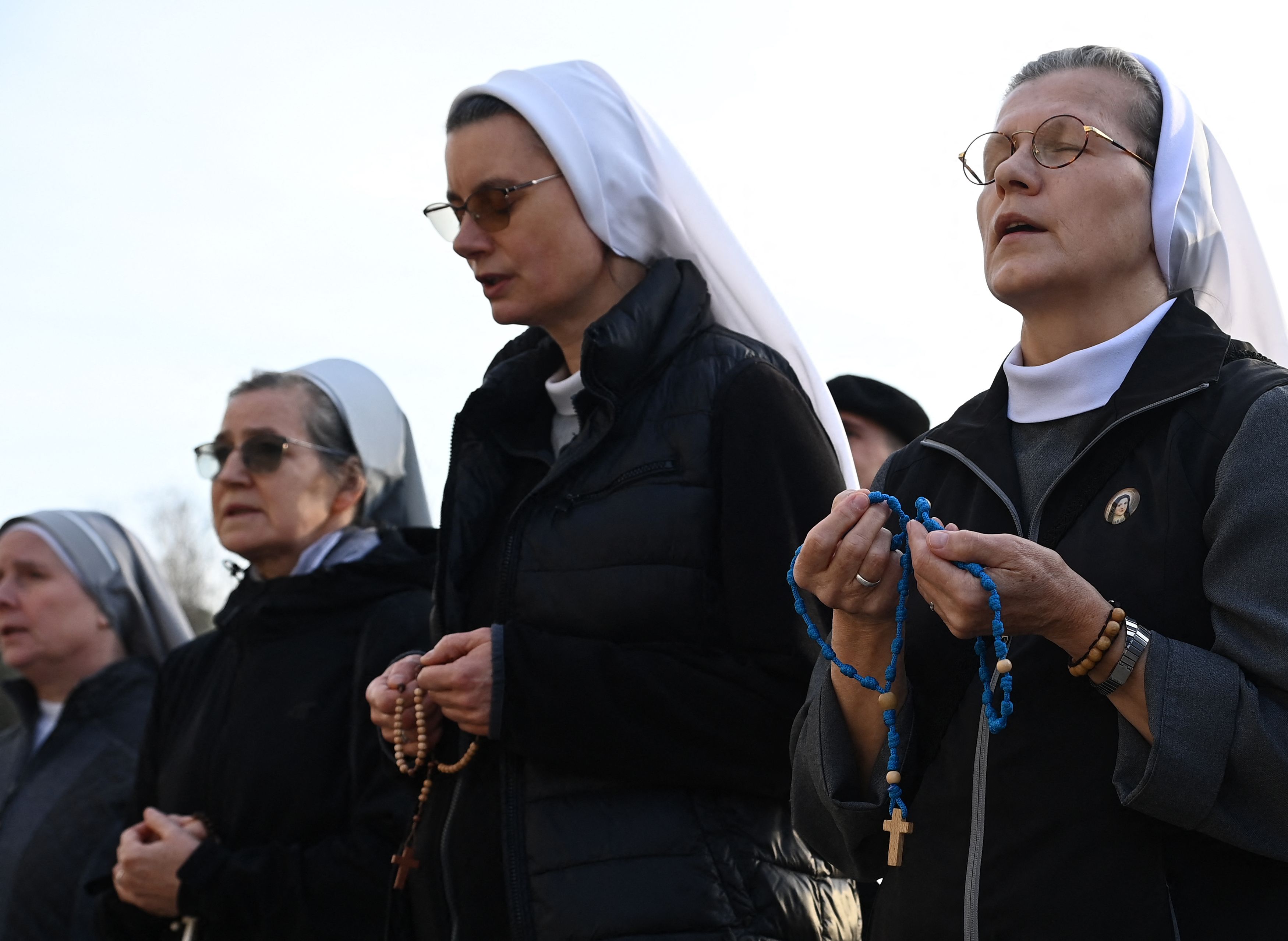 Monjas rezan el rosario afuera del hospital Gemelli donde el Papa Francisco está hospitalizado por neumonía. (Foto Prensa Libre: AFP)
