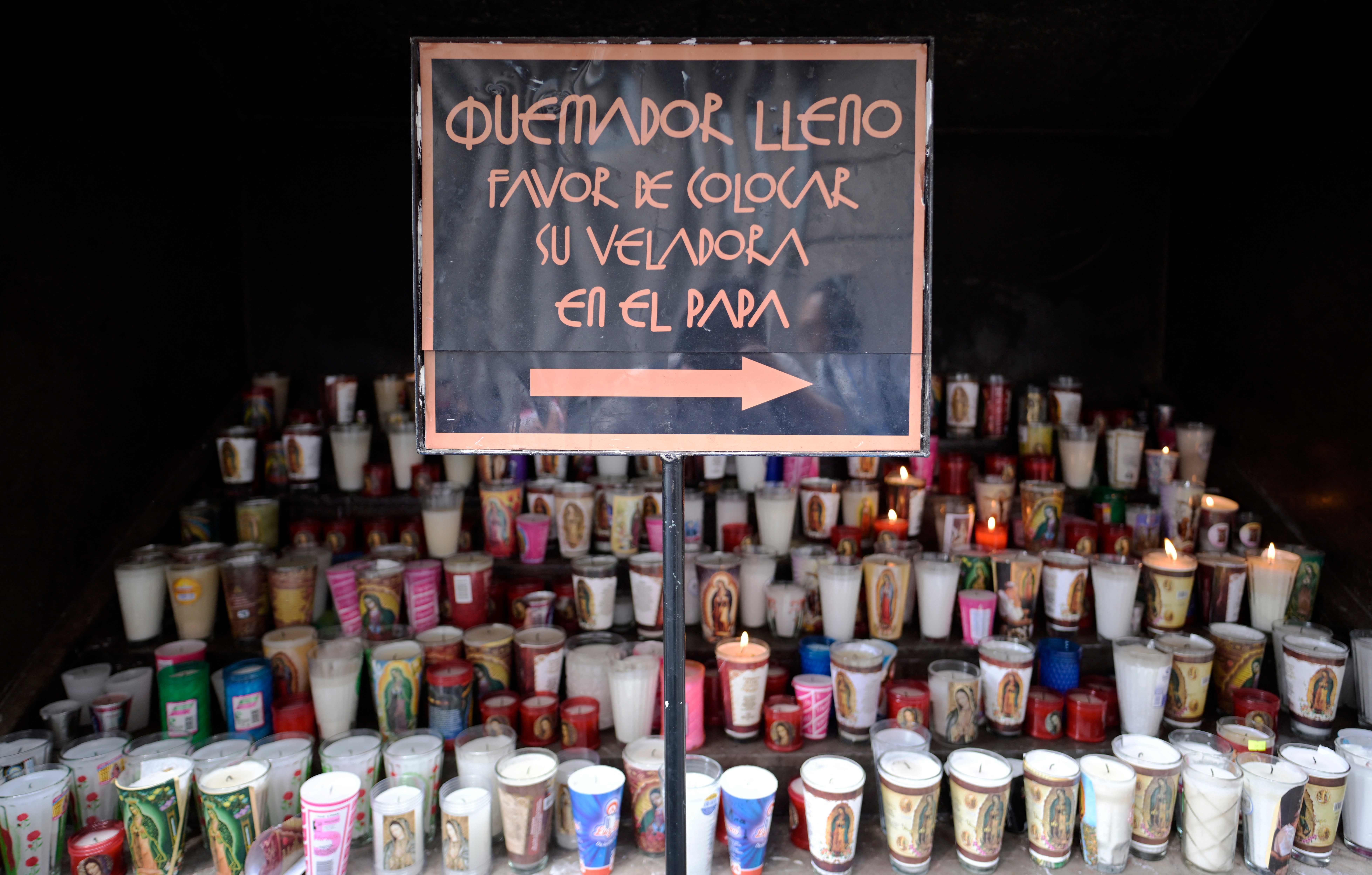 Fieles dejan velas después de una misa por la salud del Papa Francisco en la Basílica de Guadalupe en la Ciudad de México. (Foto Prensa Libre: AFP)