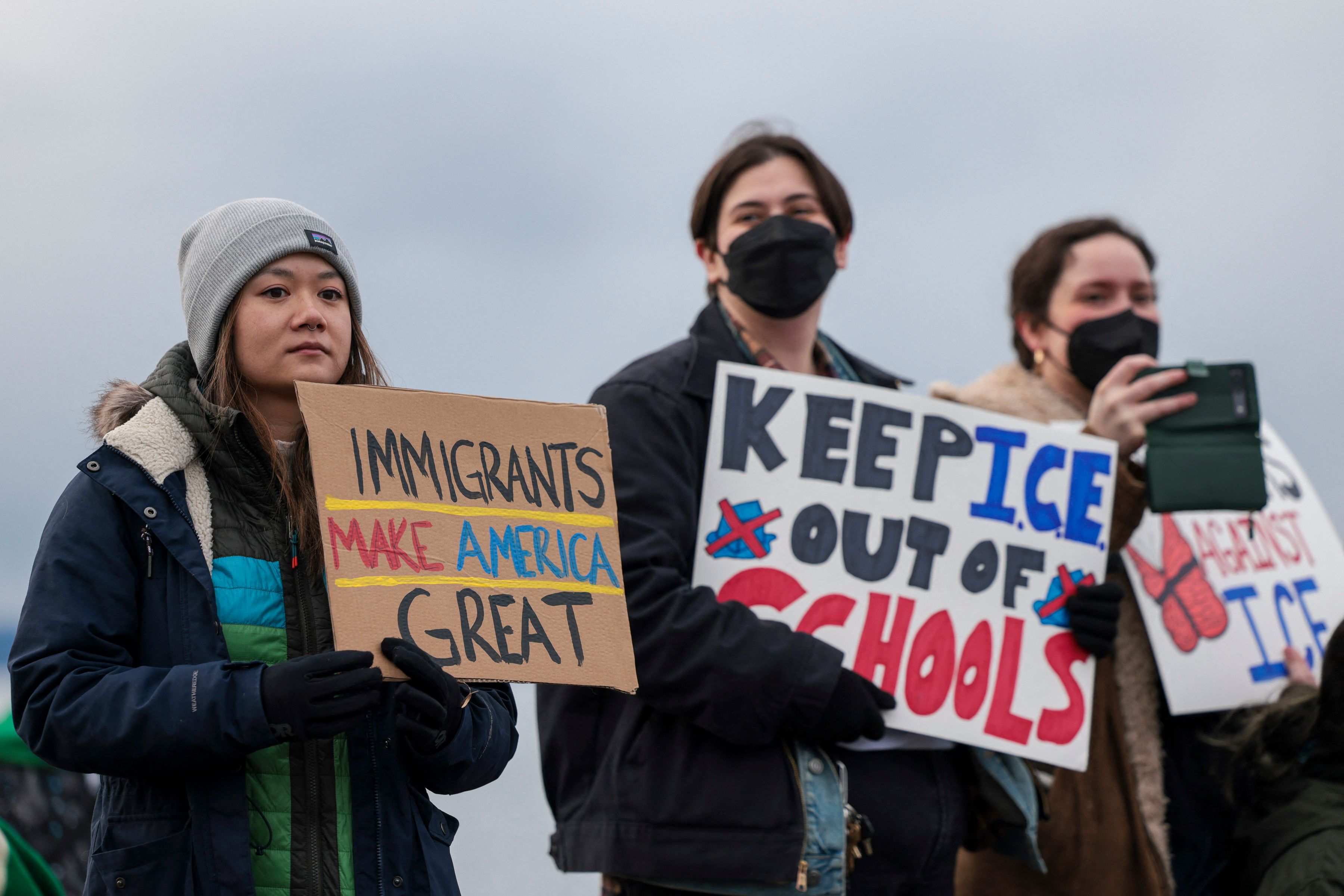 People hold signs during a march against Immigration and Customs Enforcement (ICE) entitled "Get our Gente Out of Guantanamo Bay!" in Seattle, Washington, on February 8, 2025. The US is starting to fly detained migrants to Naval Base Guantanamo in Cuba as part of President Donald Trump's crackdown on illegal migration, officials said on February 4, 2025. (Photo by Jason Redmond / AFP)