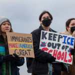 People hold signs during a march against Immigration and Customs Enforcement (ICE) entitled "Get our Gente Out of Guantanamo Bay!" in Seattle, Washington, on February 8, 2025. The US is starting to fly detained migrants to Naval Base Guantanamo in Cuba as part of President Donald Trump's crackdown on illegal migration, officials said on February 4, 2025. (Photo by Jason Redmond / AFP)