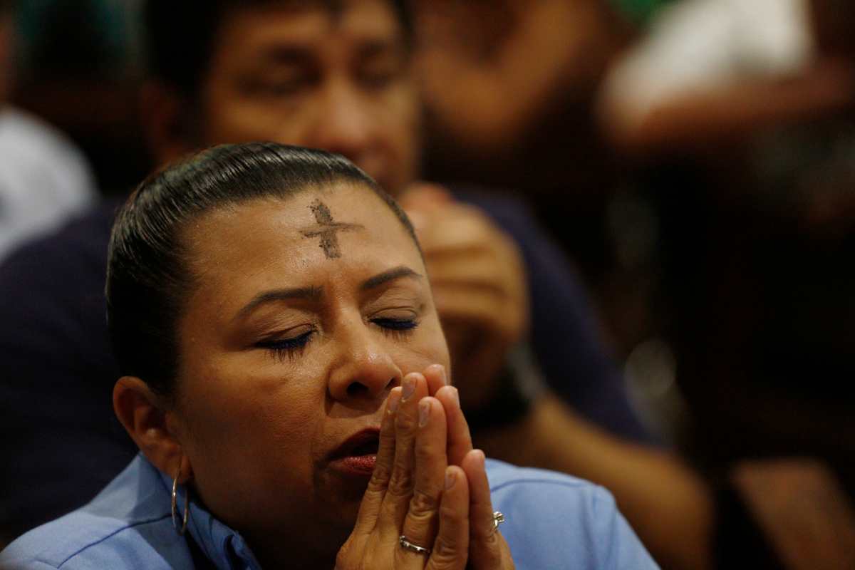Una mujer reza en una misa durante una celebración del Miércoles de Ceniza. (Foto Prensa Libre: EFE)