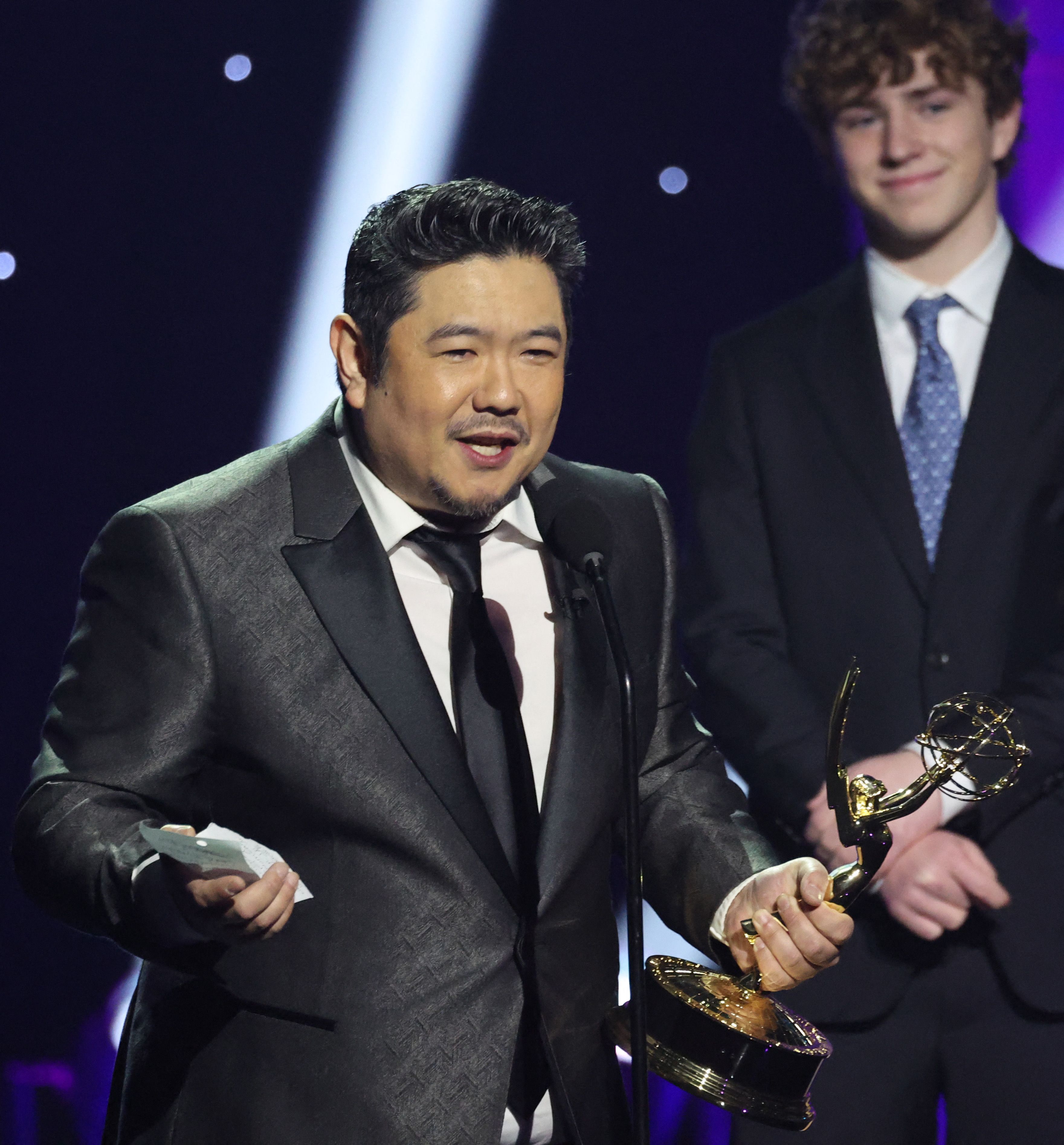 LOS ANGELES, CALIFORNIA - MARCH 15: Eric Bauza accepts the Outstanding Voice Performer in a Children's or Young Teen Program award for "Teen Titans Go!" onstage from Walker Scobell during the 3rd Annual Children's and Family Emmy Awards at Television City Studios on March 15, 2025 in Los Angeles, California.   Amy Sussman/Getty Images/AFP (Photo by Amy Sussman / GETTY IMAGES NORTH AMERICA / Getty Images via AFP)
